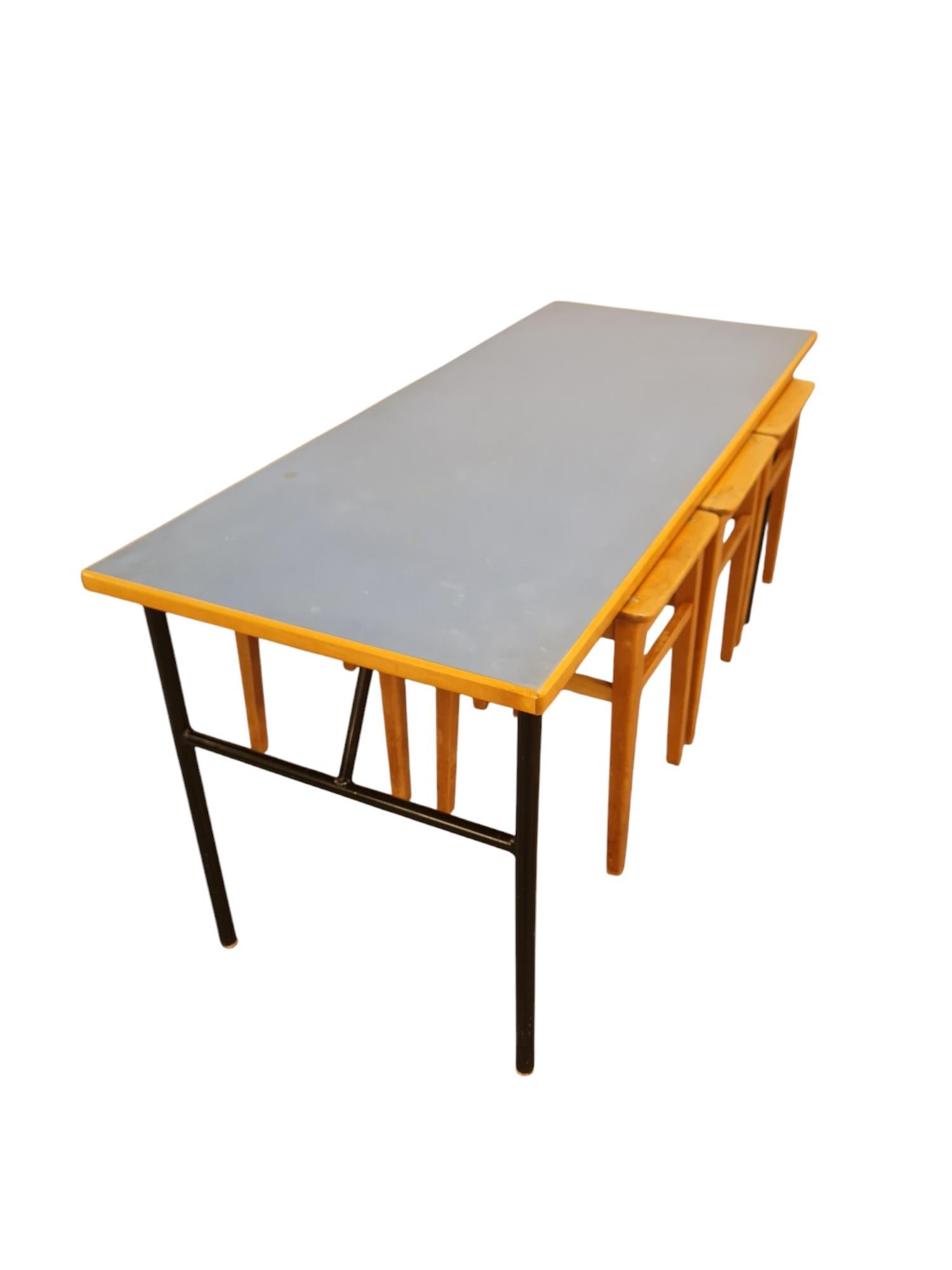 Magnifique et ludique ensemble table et tabouret de style moderne du milieu du siècle dernier, datant des années 1950. Le design/One permet aux tabourets de s'emboîter sous la table en les soulevant du sol, ce qui facilite par exemple le nettoyage.