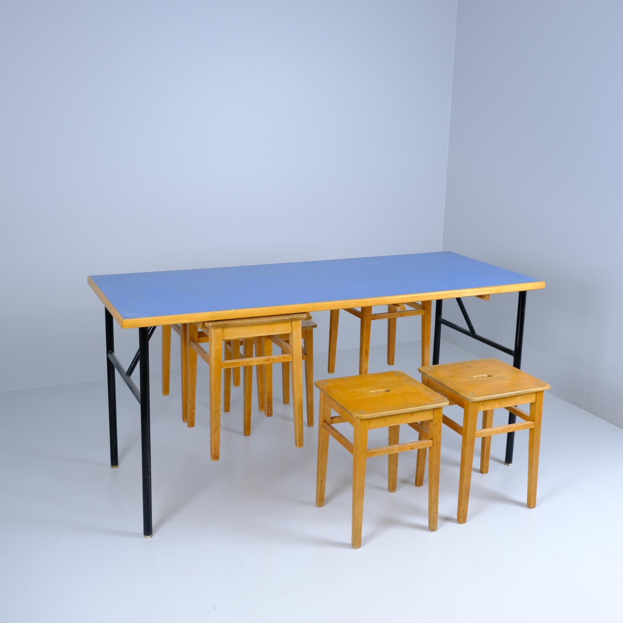 A wonderful and playful Mid-Century Modern table and stool set from 1950s. The brilliant design allows for the stools to nest under the table lifting them from the floor which eases for example the cleaning. Perfect for studios, teaching spaces,
