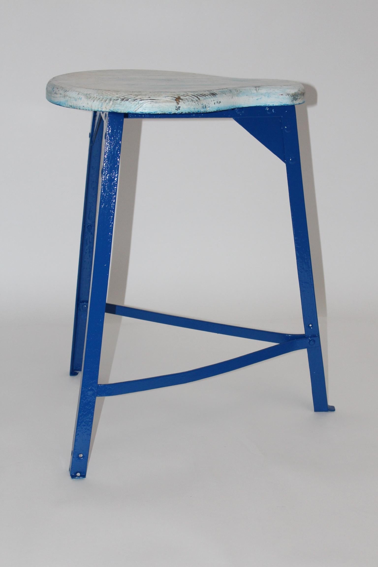 This stool shows a newly blue lacquered three legged metal frame with a shaped seat, made of spruce.
So the seat features color rests.
The vintage condition is very good. 
Approx. measures:
Width: 47 cm
Depth: 55 cm
Height: 62 cm.