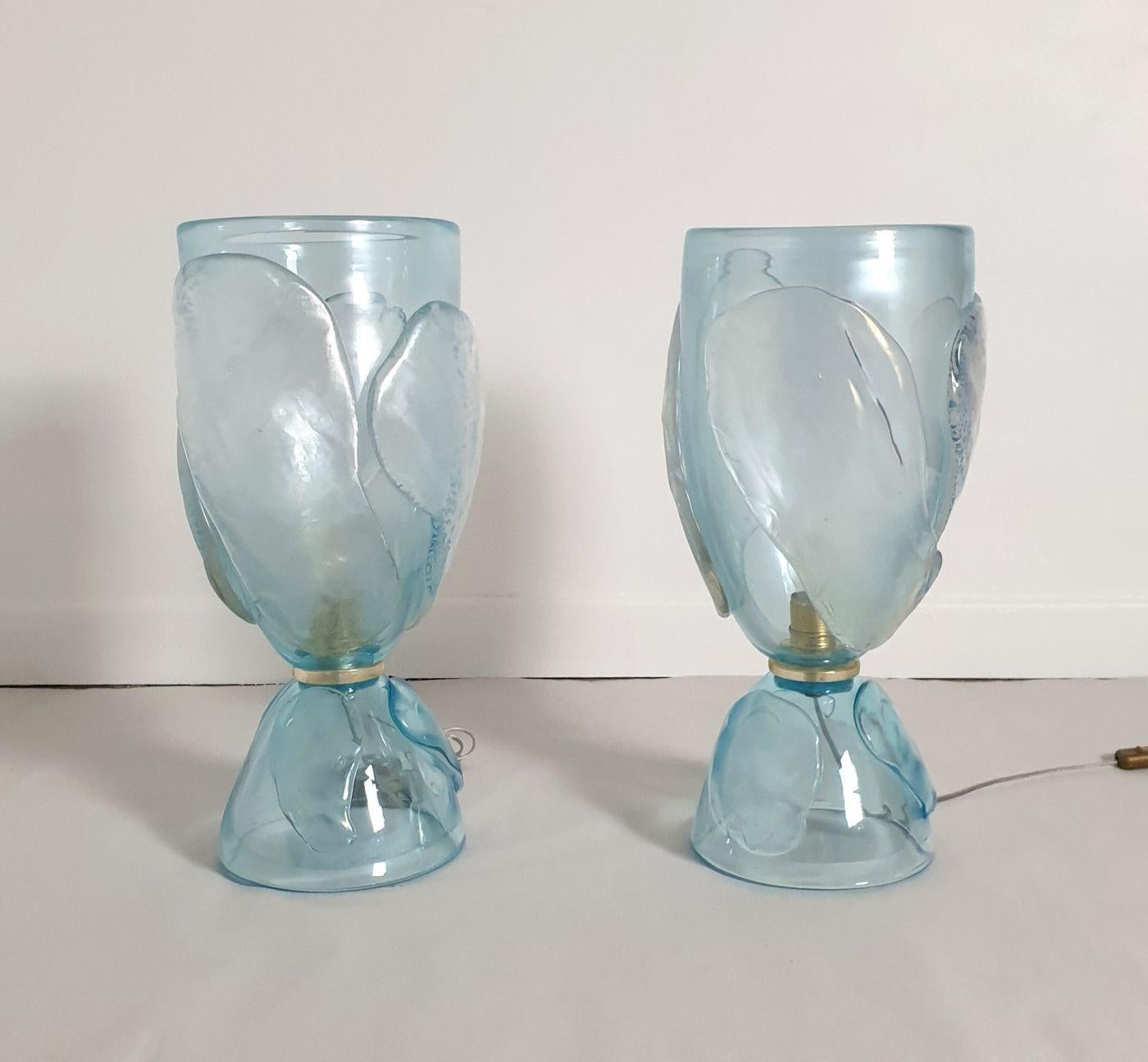 Paire de grandes lampes en verre de Murano bleu ciel, Italie 1970, attribuées à Seguso.
La paire de lampes vintage est fabriquée à la main dans un verre de Murano épais et lourd.
Le verre est d'un bleu ciel transparent et devient translucide avec la