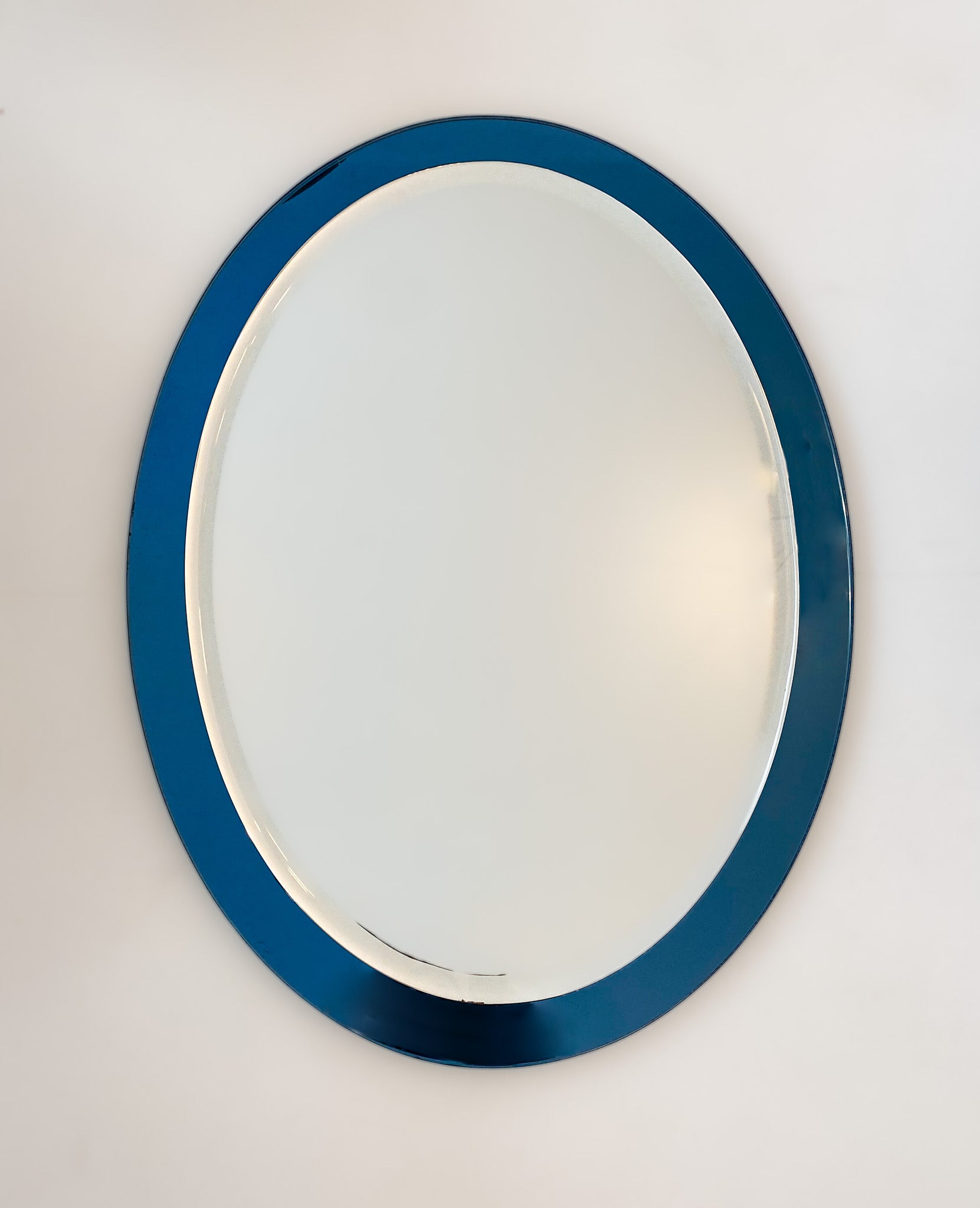 Mid-Century Modern blue oval glass wall mirror, Italy 1970s.

Elegant Mid-Century Modern blue Italian oval shaped wall mirror from the 70s. This wall mirror has a unique frame of deep blue mirrored glass. The mirror itself has a beautiful polished