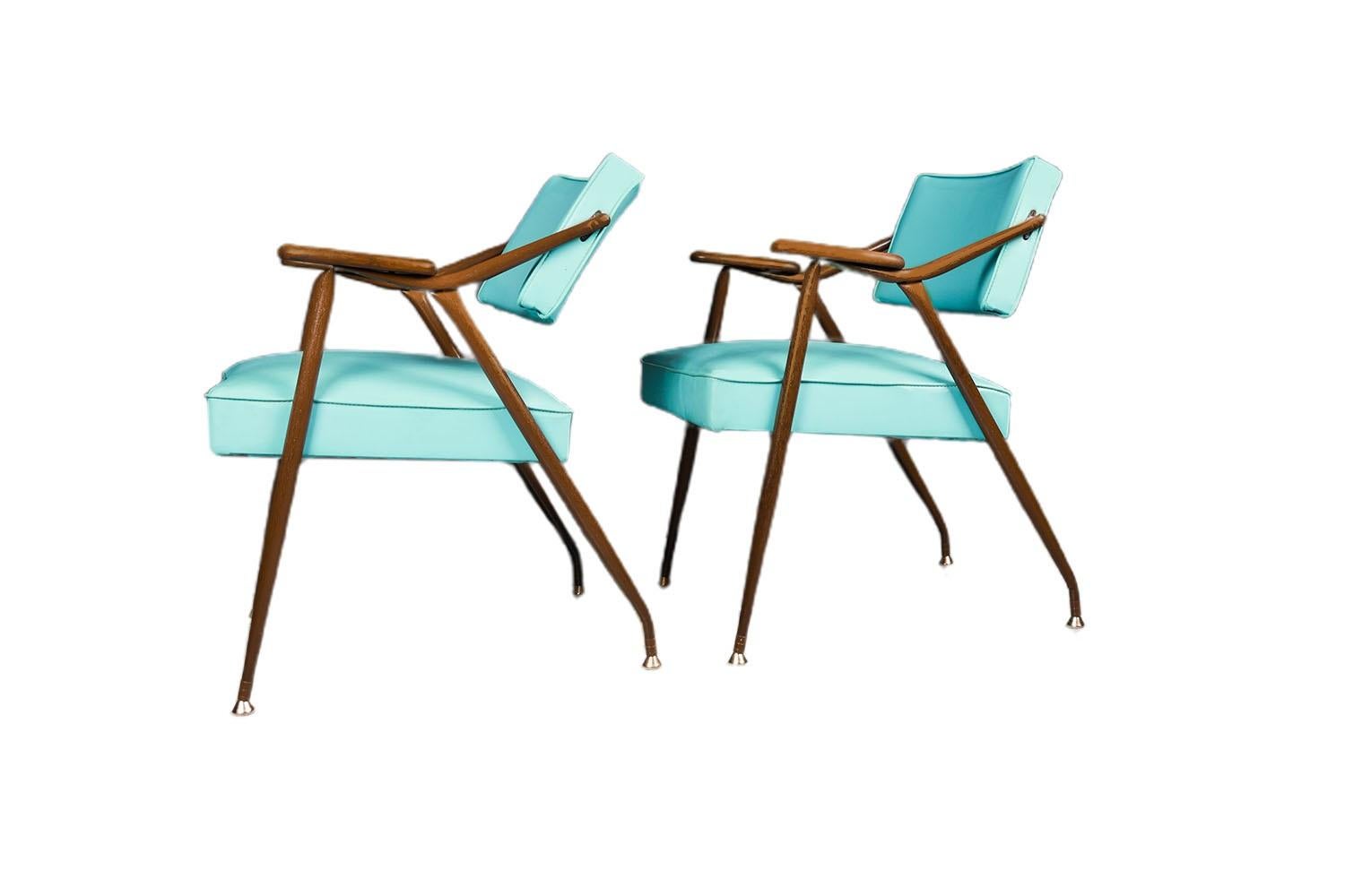 A gorgeous matching pair of lounge chairs by Viko Baumritter, USA, circa 1959. These Mid-Century armchairs have the lean of a lounge chair and the poise to draw attention. The dynamic sheen of the blue vinyl upholstery has an undeniable retro