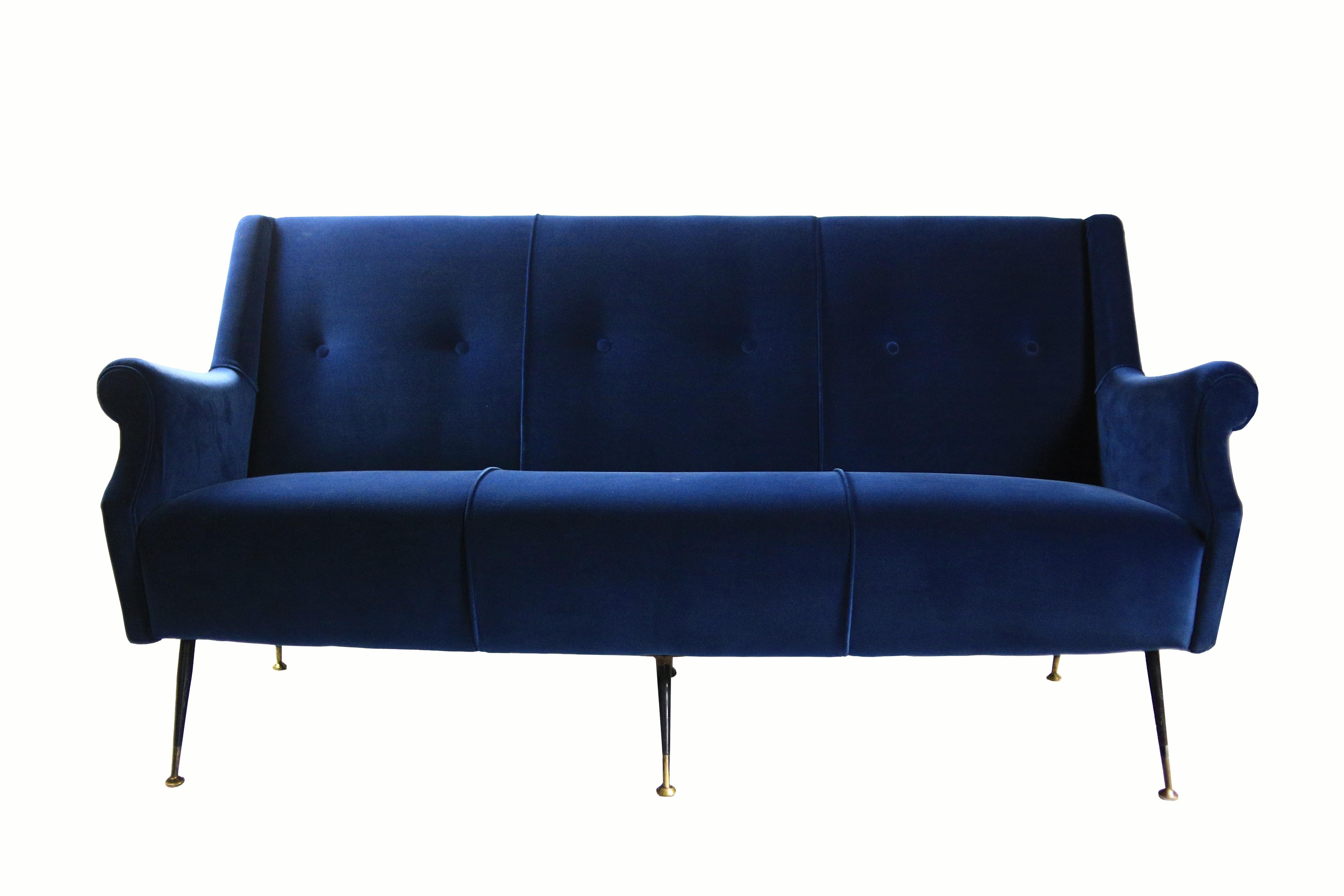 A stunning Mid-Century Modern three-seat Italian sofa, covered in royal blue cotton velvet. The sofa features sculpted armrests and its structure is made of solid wood, with six metal legs and brass feet. Newly refurbished, this sofa is in perfect