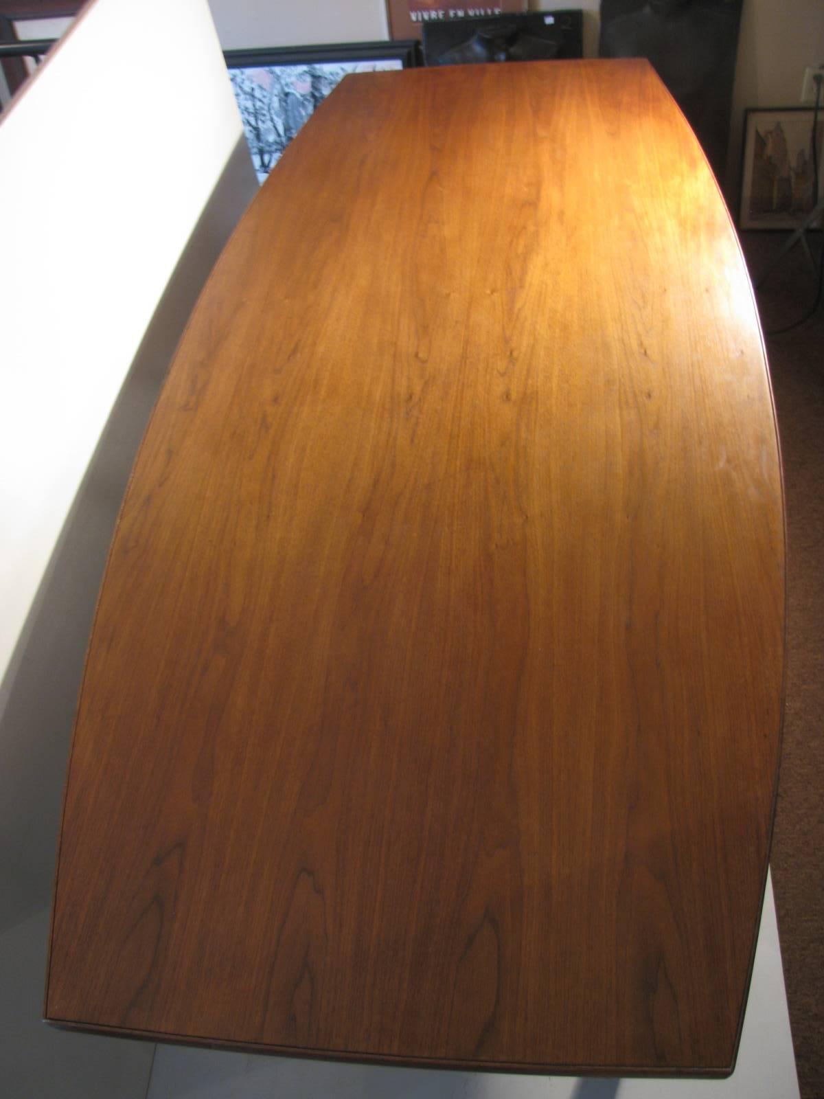 Refinished black walnut conference or dining table. Long and sleek in the shape of a boat table offers a large surface of fabulous black walnut for dining or business. Table top tucks in at both ends.