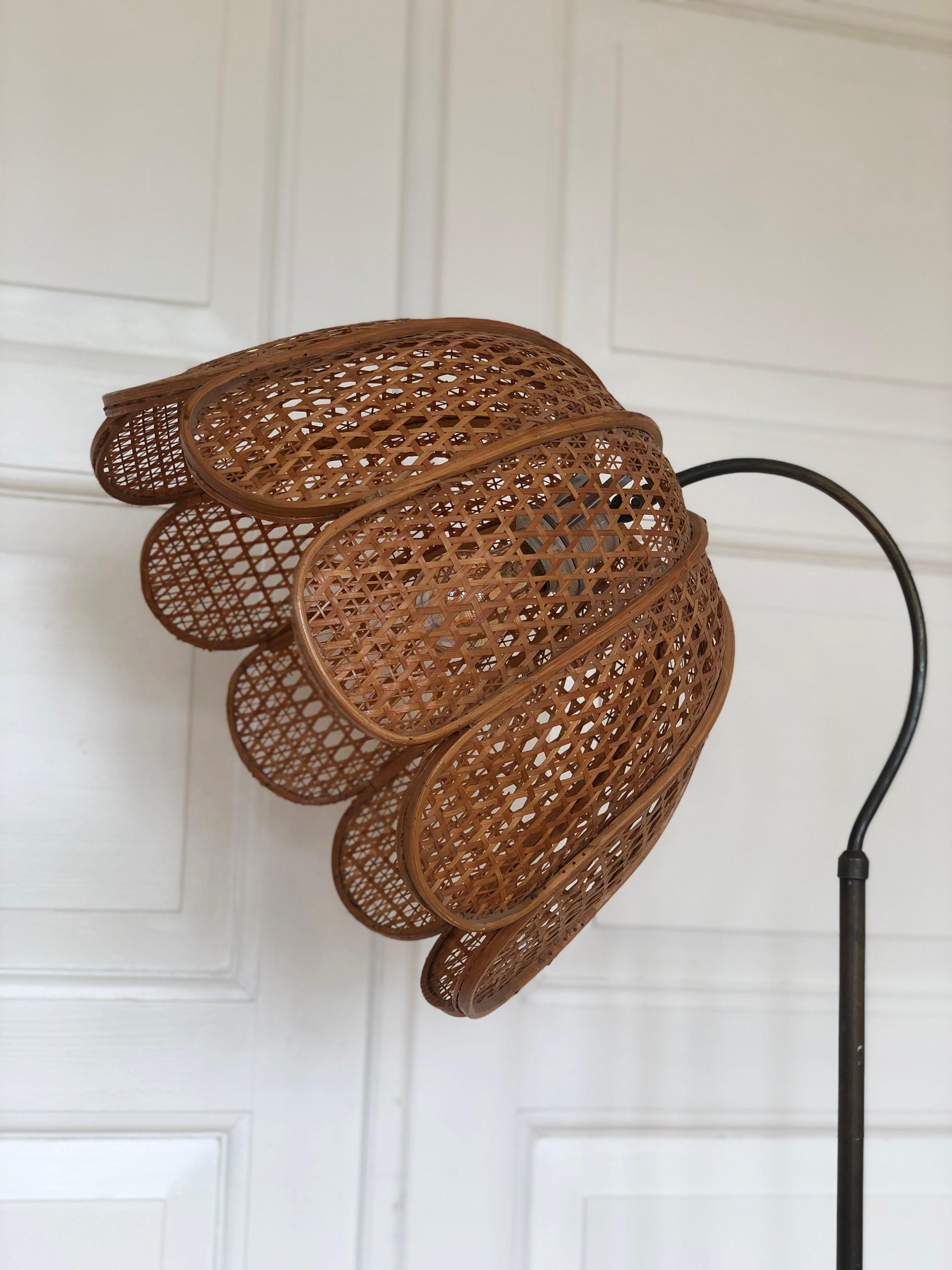Stylish floor lamp reflecting Scandinavian and boho design from the 1970s. Features a handmade rattan shade that can rotate, a solid brass base, and a heavy weighted foot for stability. The base is marked with an engraved number.

Object: Floor