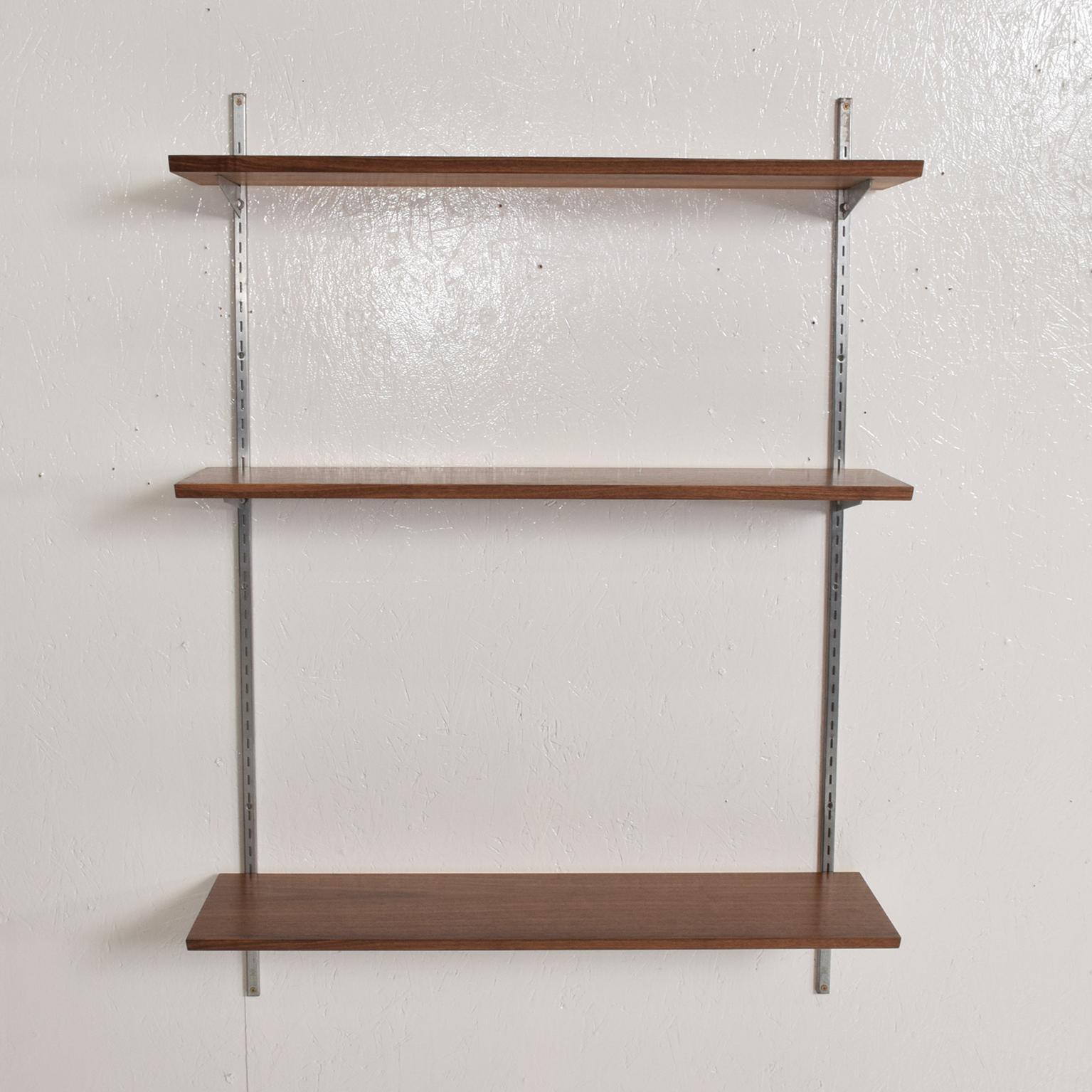 For your consideration, a vintage bookcase shelving wall unit, one bay. Constructed with walnut shelves and aluminum brackets, metal uprights. The USA, circa 1960s. 

Dimensions: 48 1/2