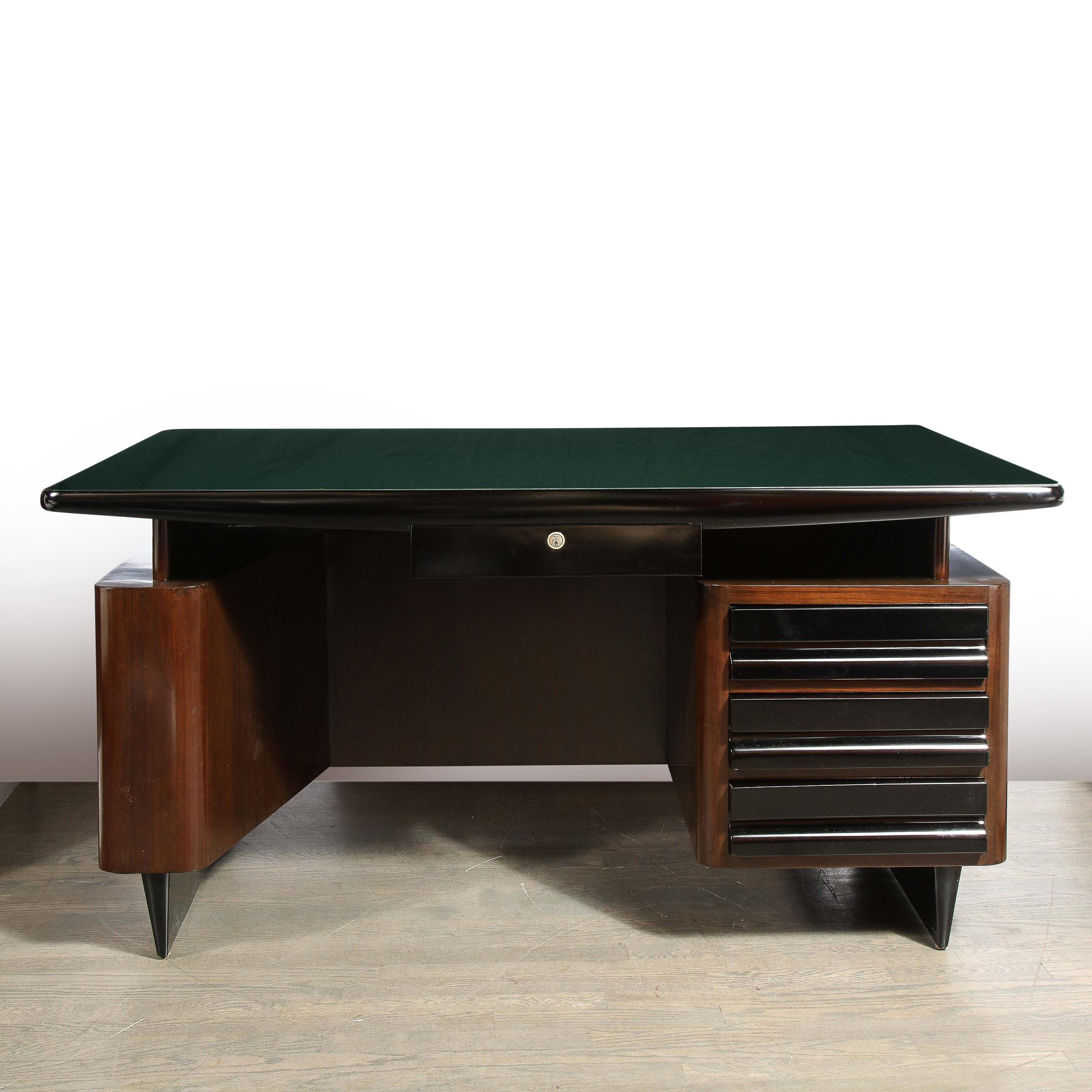This sophisticated Mid-Century Modern desk was realized in Italy in 1948. It features tapered volumetric triangular atomic form black lacquer legs at the base that support a stylized rectilinear body in sumptuous bookmatched walnut with a vertical