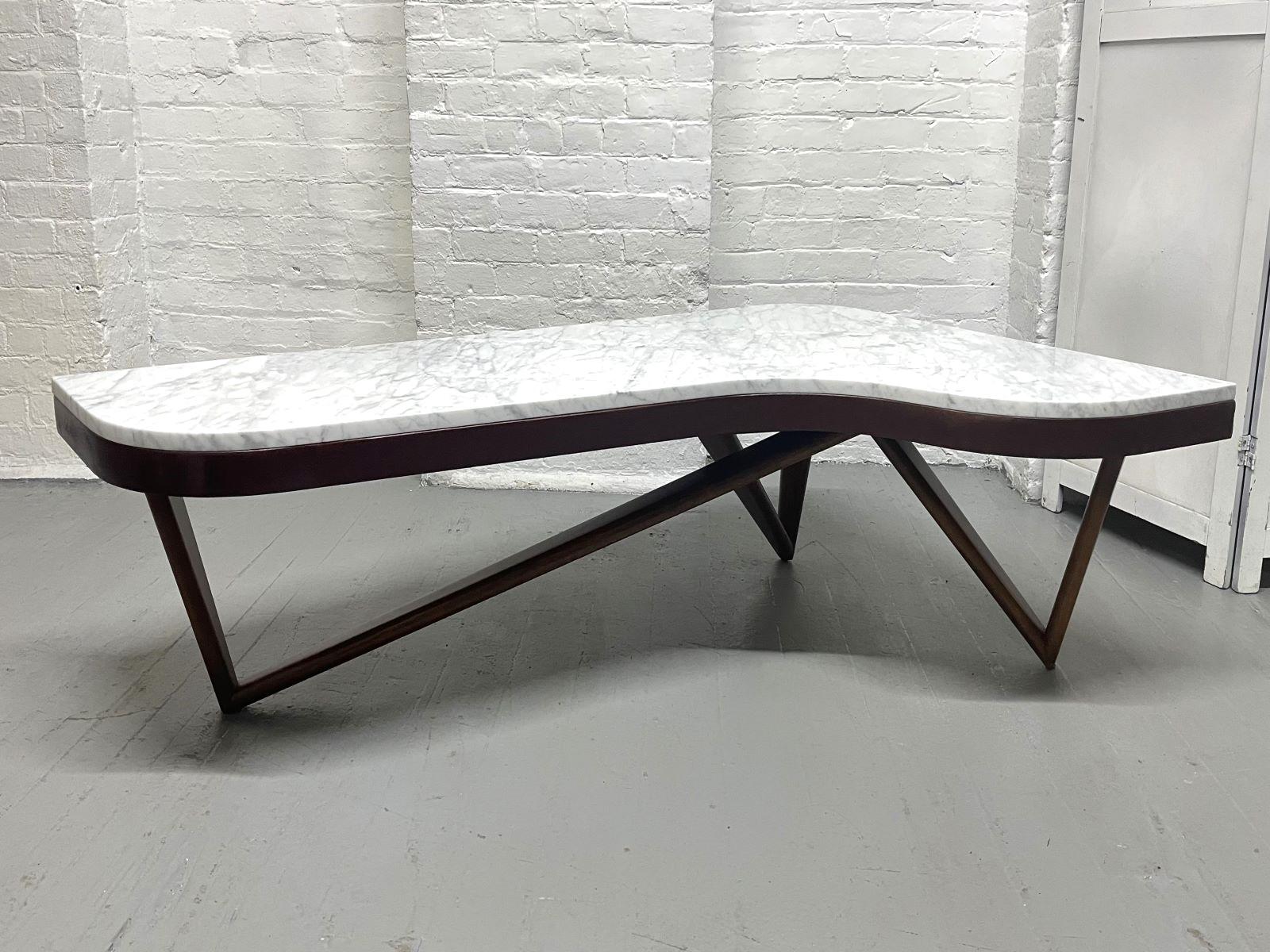 Moderner Couchtisch in Form eines Bumerangs aus der Jahrhundertmitte. Der Tisch ist aus Mahagoni mit einem skulpturalen Sockel und einer Marmorplatte.
