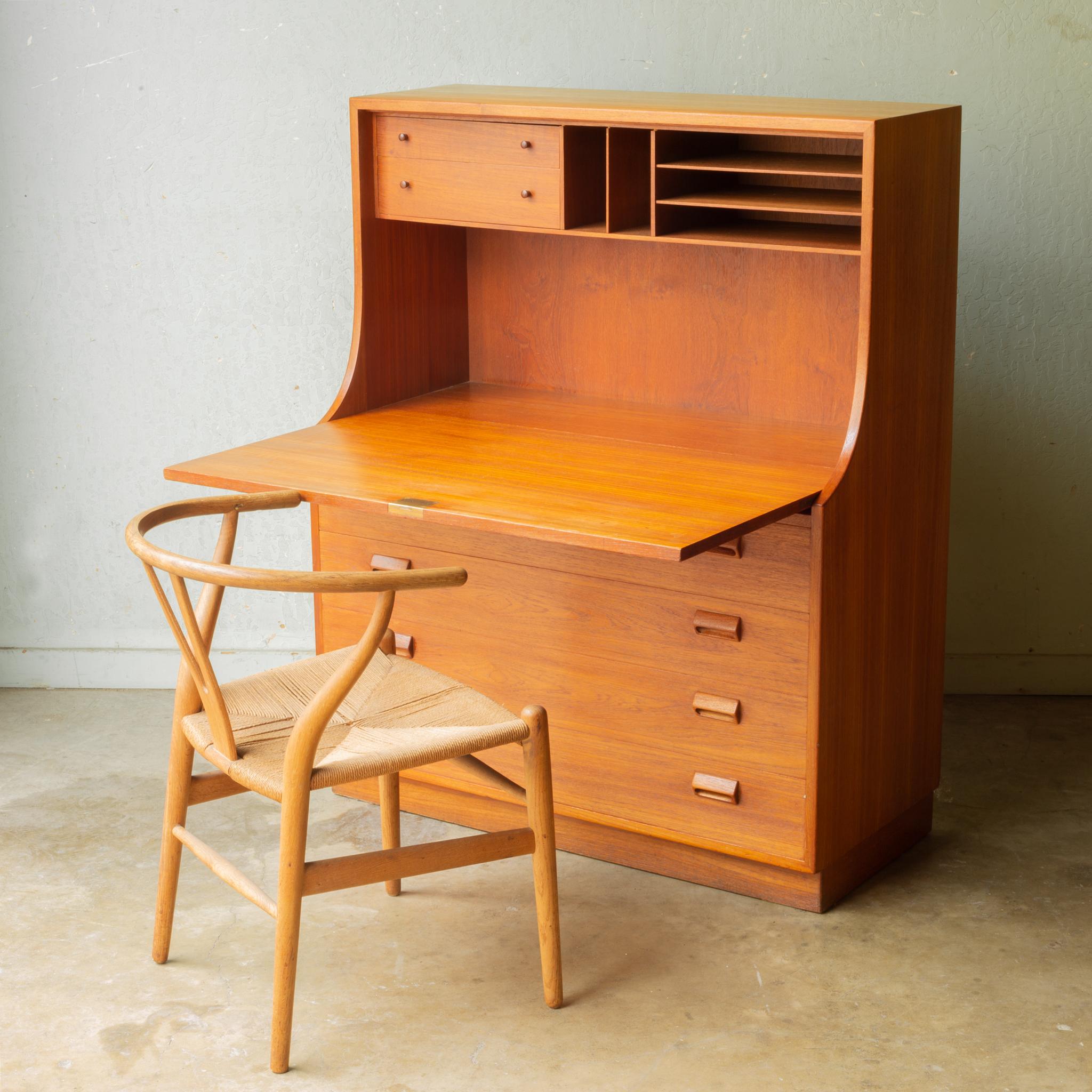 About

This is a teak secretary/desk designed by Borgo Mogensen for Soborg Mobler. This statement piece has rich wood grain and sharply, curved drawer pulls. Drop the lid down and it converts into a desk with space for a laptop, multiple cubbies