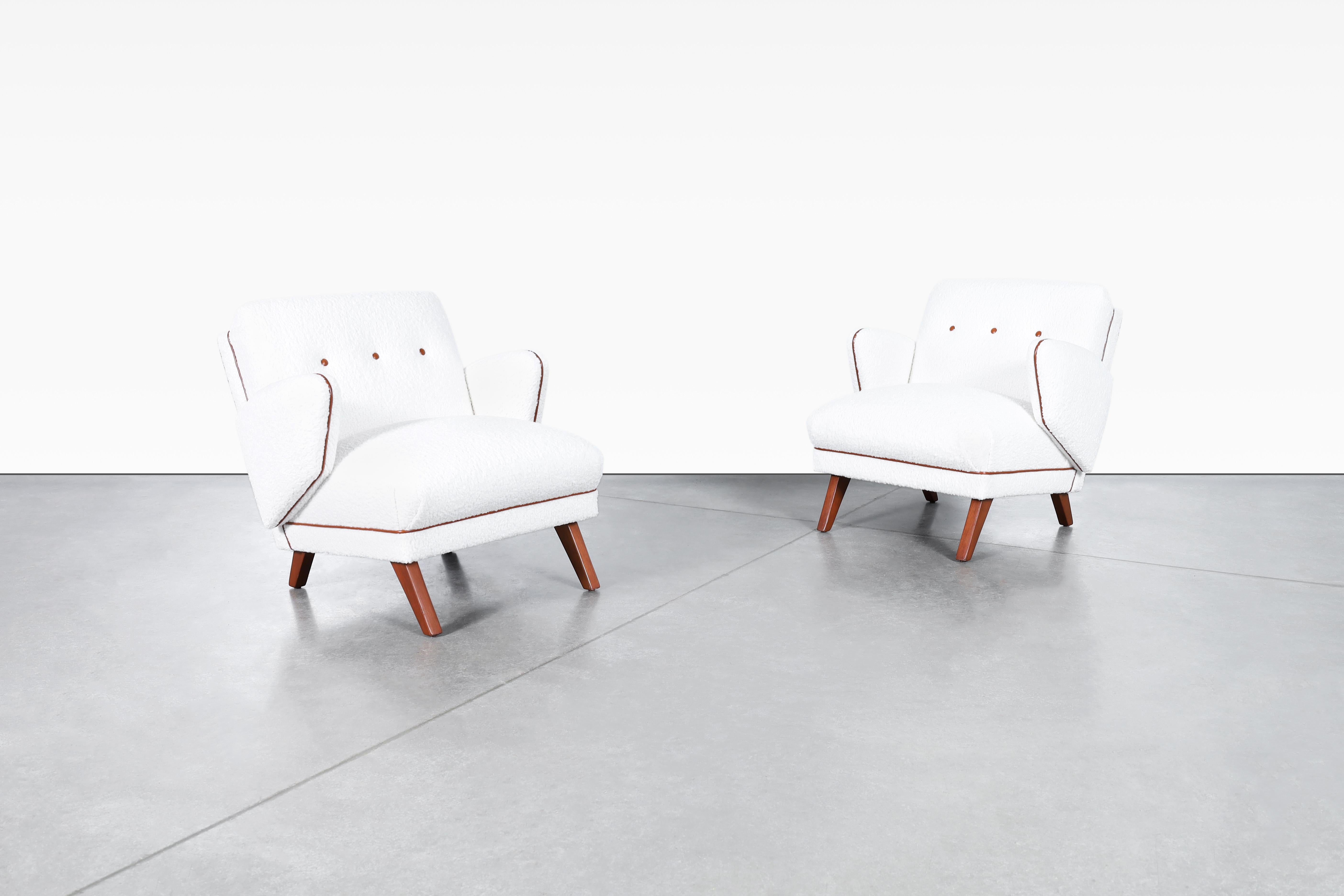 These mid-century modern lounge chairs are a true masterpiece of craftsmanship and design. Produced in the United States during the 1950s, they have been professionally restored to give them a new life. The chairs feature a beautiful Italian boucle