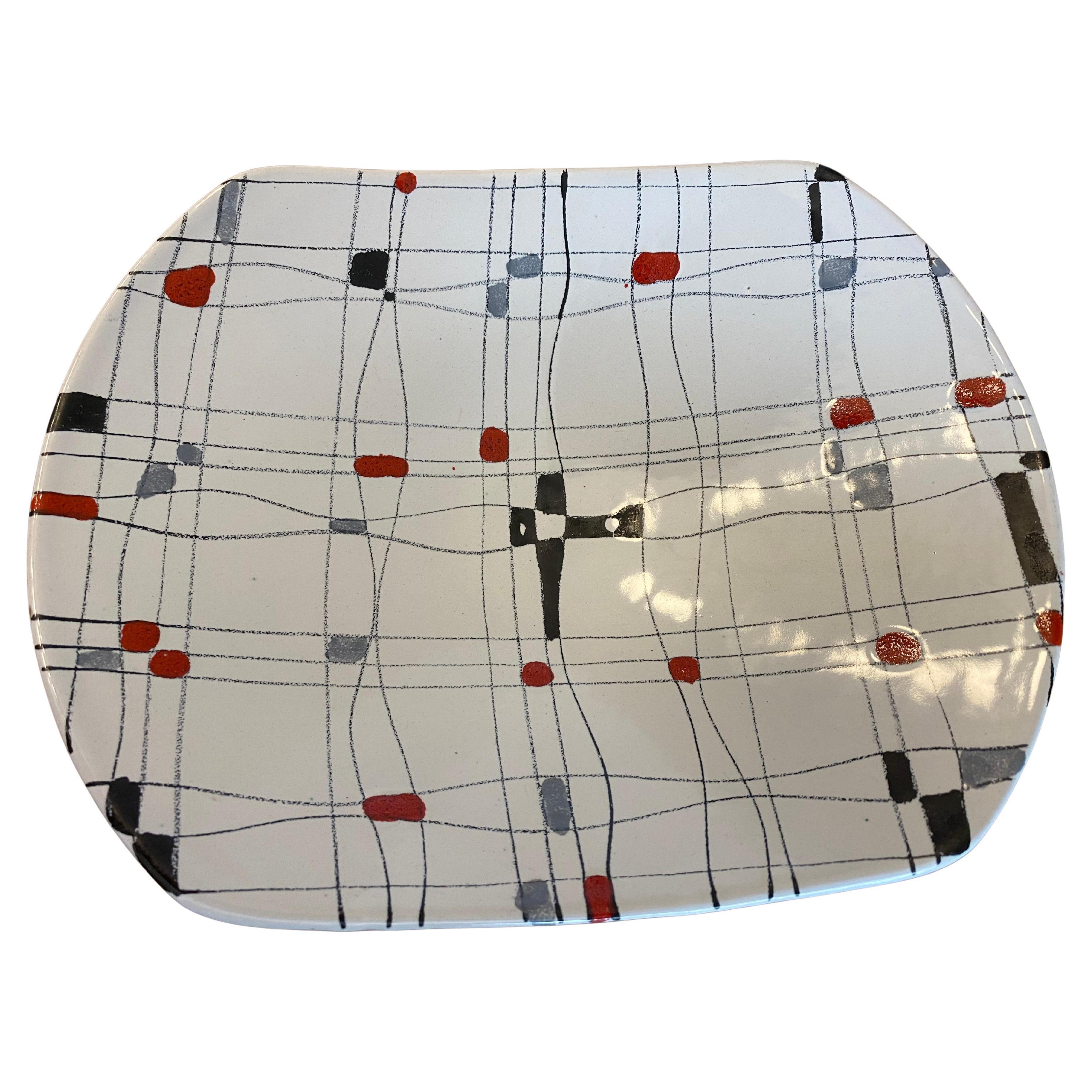 Bol en céramique Bistossi de style moderne du milieu du siècle, avec un motif de mots croisés stylisés composé de lignes sinueuses et de carrés en rouge, gris, bleu et noir sur un fond blanc glacé à la texture douce. 
