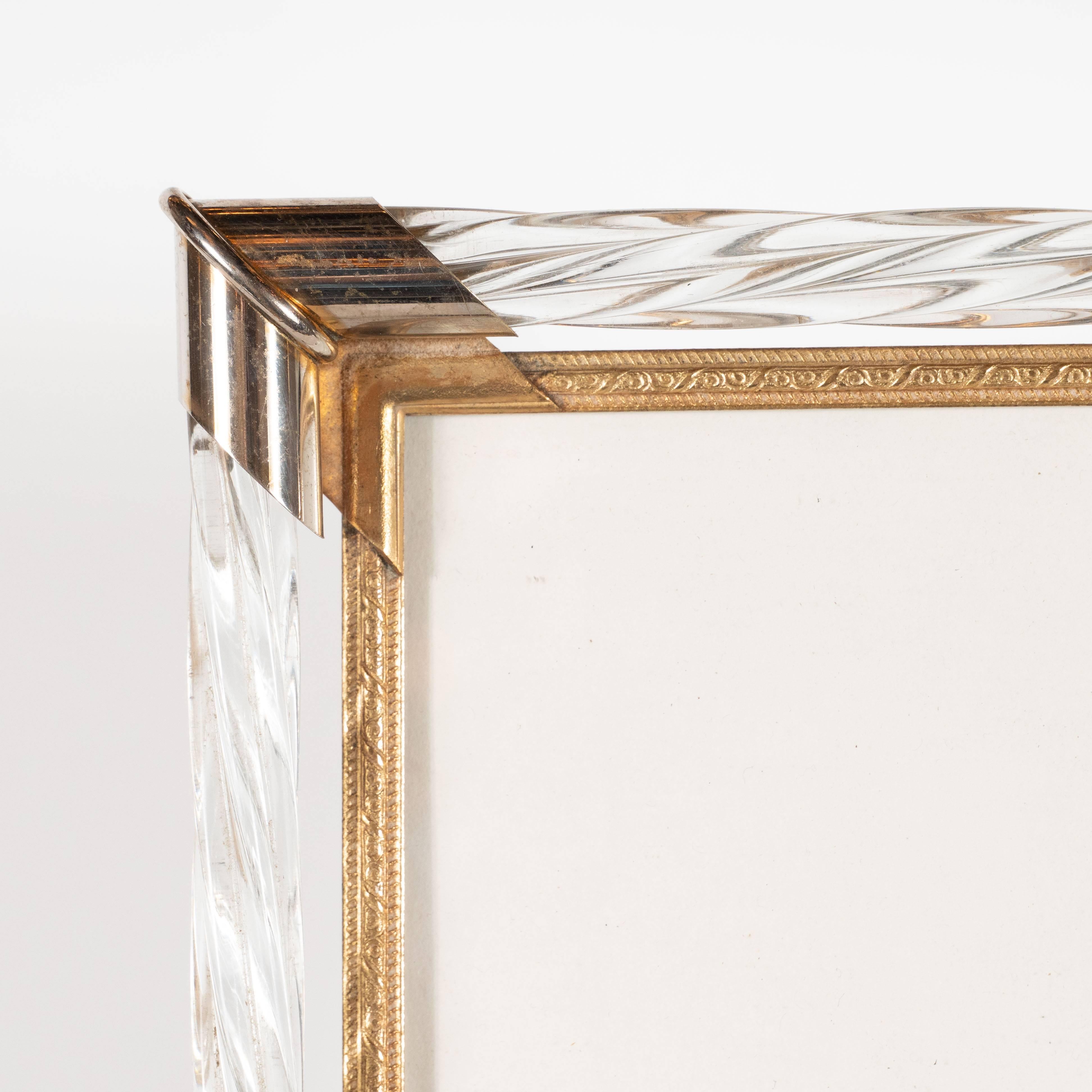 This elegant Mid-Century Modern picture frame was realized in Murano, Italy, circa 1950. It features a brass frame with channel and foliate detailing on the front and floral motifs on the side. Above the brass frame, there is a raised perimeter with