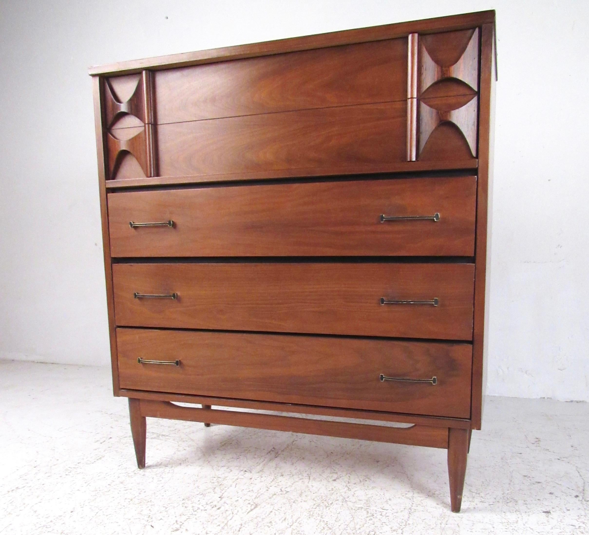 This unique midcentury dresser features striking natural wood finish, Brasilia style sculptural drawer fronts, and unique raised edge top. Compact bedroom storage come with five spacious drawers perfect for organizing clothes and other necessities.