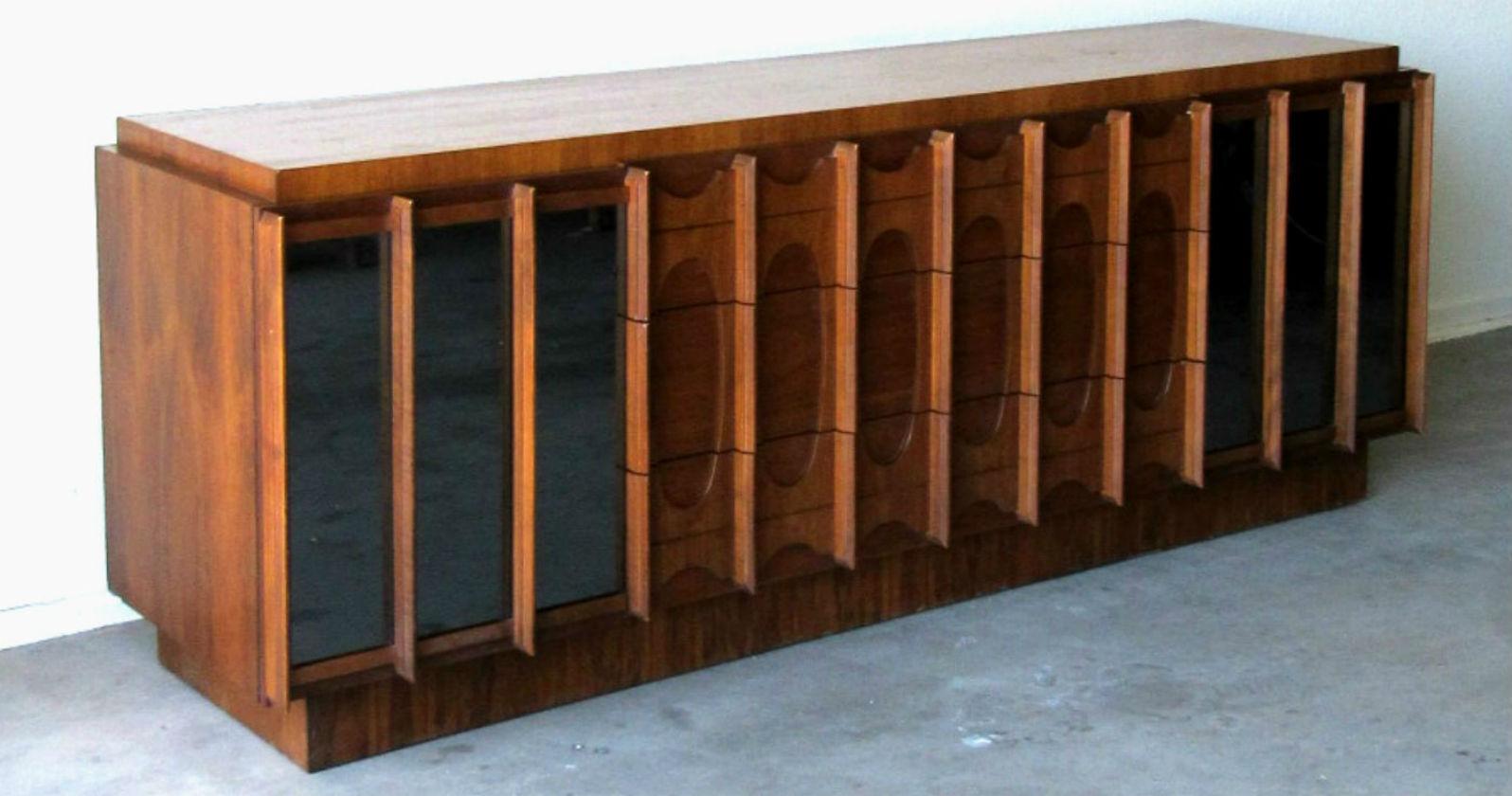Midcentury Modern Brasilia Style Dresser with Mirrored Front.  Walnut dresser, made in Canada 1960s   In the popular Brasilia style referencing the work of Oscar Niemeyer.   Dresser features nine drawers and has generous storage.  