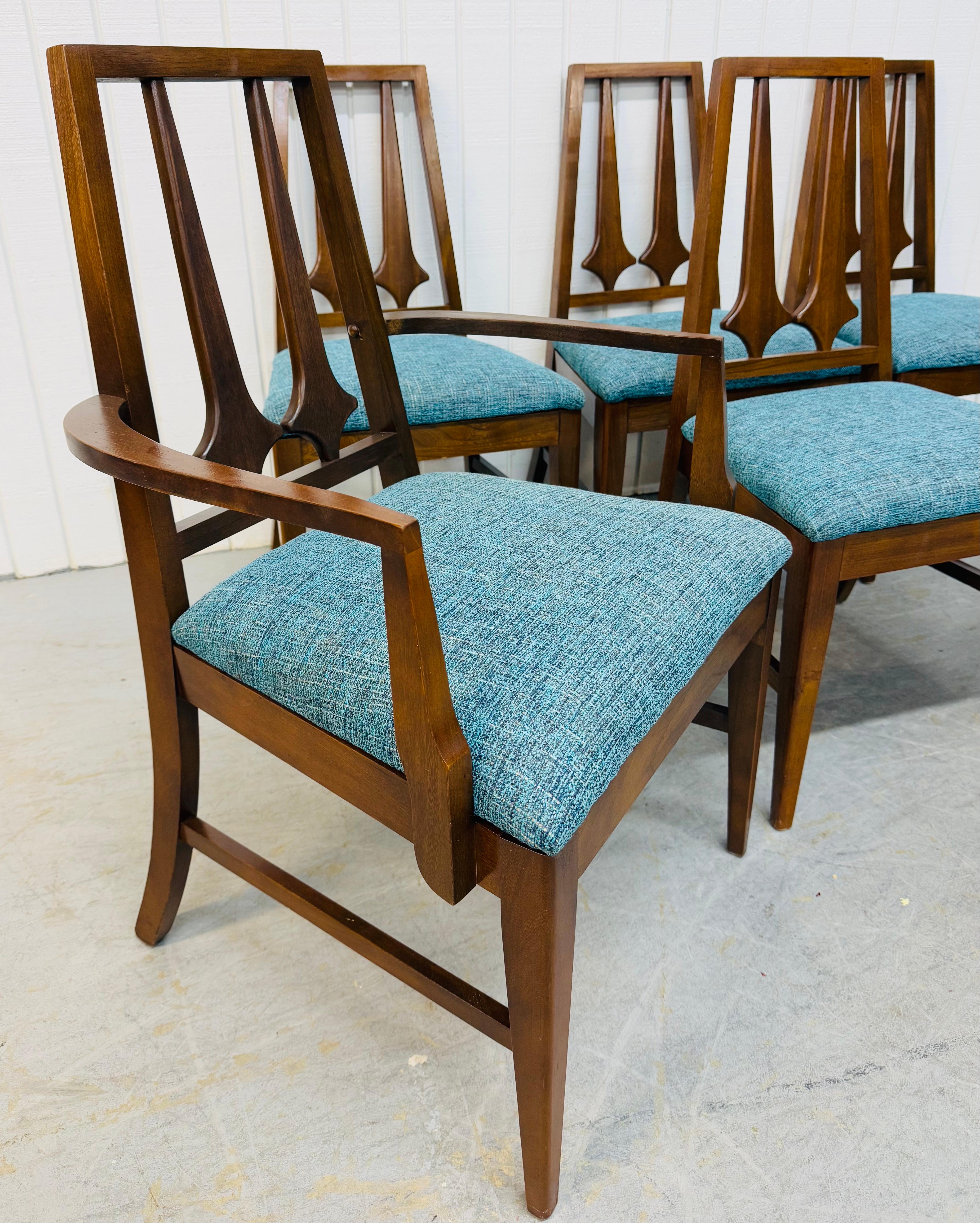 This listing is for a set of six Mid-Century Modern Brasilia Style Walnut Dining Chairs. Featuring two arm chairs, four side chairs, sculpted back rests, modern legs, new upholstered seats, and a beautiful walnut finish. This is an exceptional