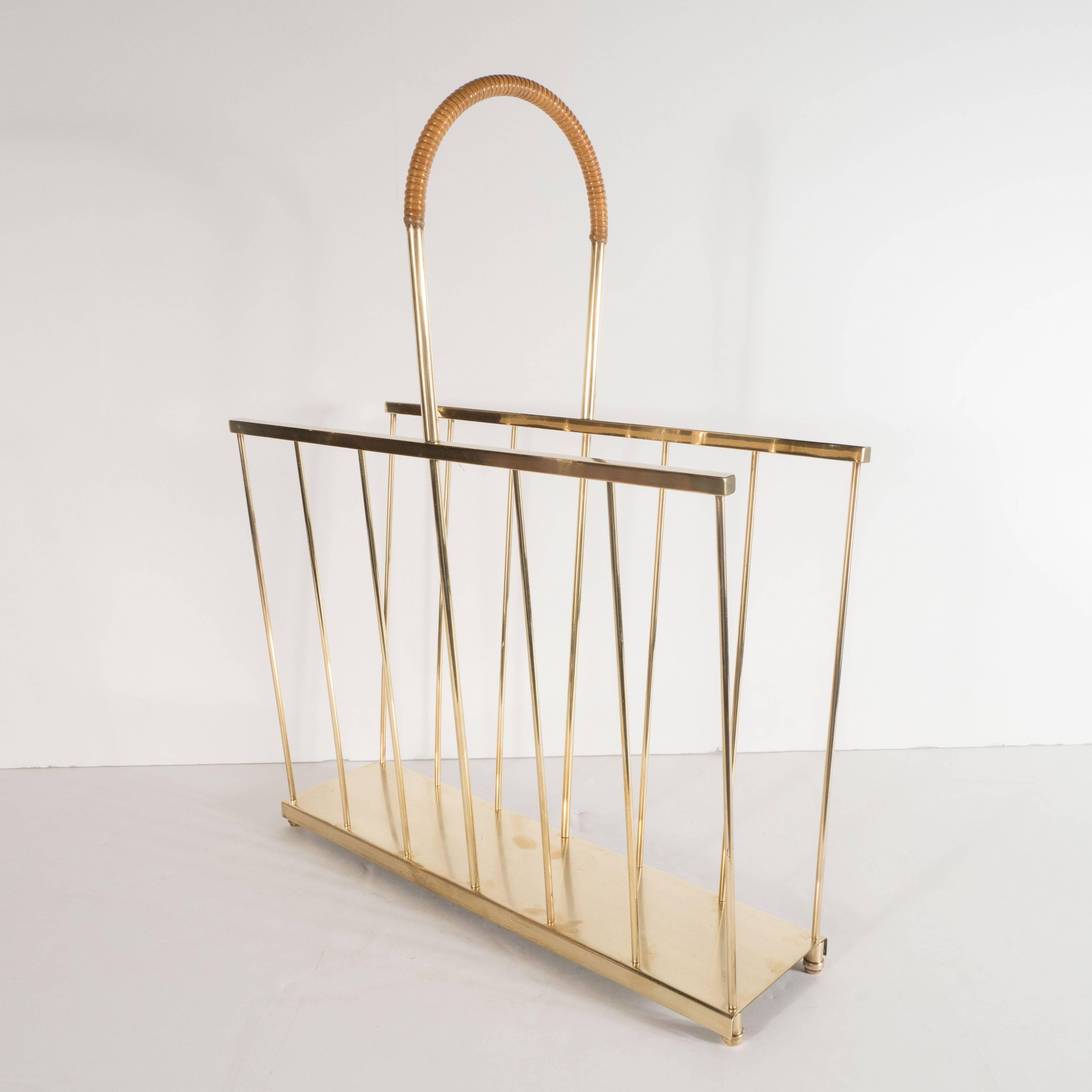 This elegant and refined magazine Stand was realized by the celebrated New York producer Maxwell-Phillips, circa 1960. It features a rectangular base with two inverted sides set at opposing angles composed of vertical rods in brushed brass. It