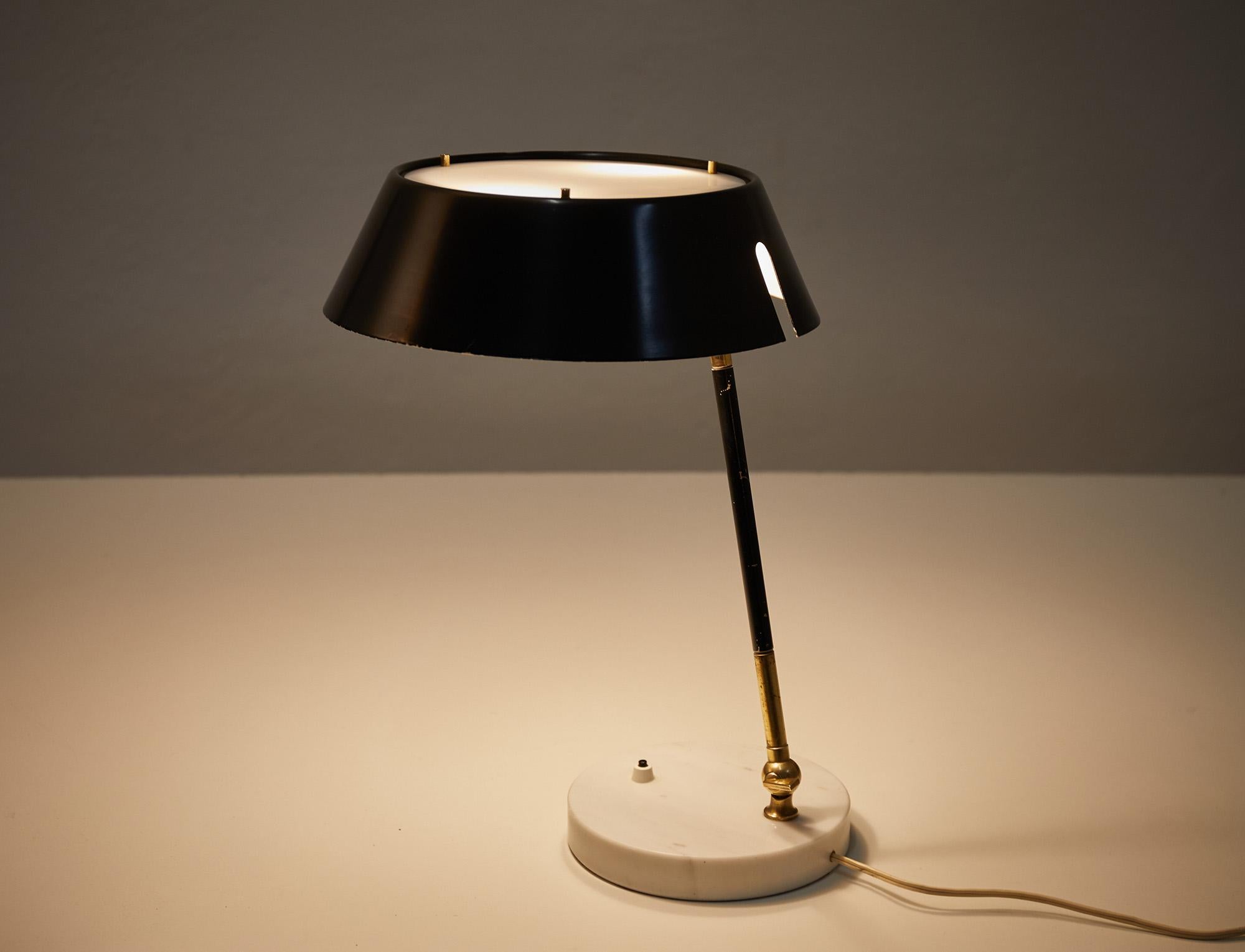 Elegant adjustable table or desk lamp designed and manufactured by Stilux, Italy around 1960. 

The lamp features a round black metal shade with on top a plexiglas diffuser for a soft light effect. The brass stem with a black lacquered middle piece