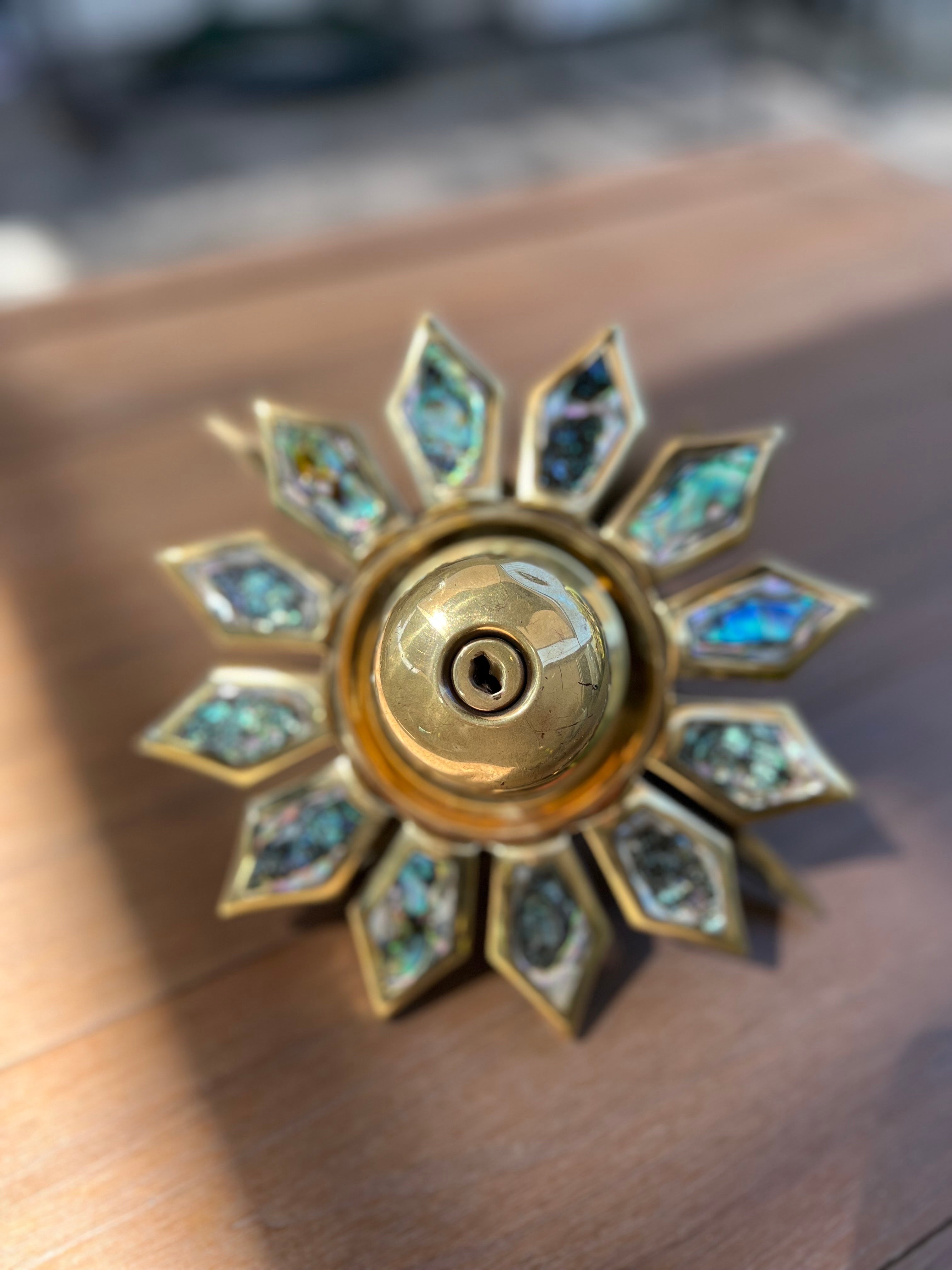 This knob has the two sides of a door, thinking in a common sense, interior and exterior side, on one side the Aztec sun, generally seen outside, and on the other the iconic mid-century star that would be on the inside side. All brass has been fully