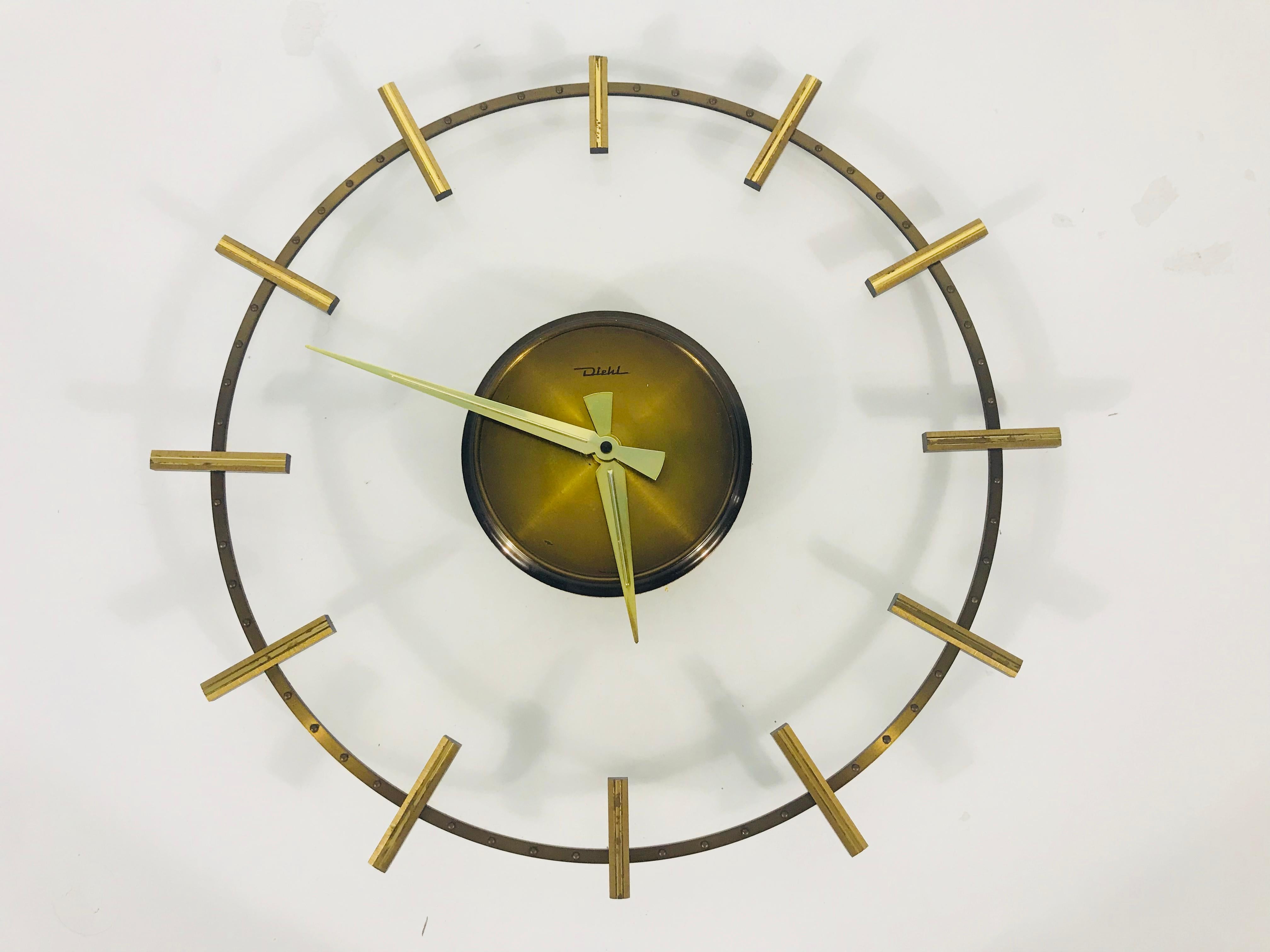 Eine außergewöhnliche Wanduhr von Diehl aus den 1960er Jahren. Sie hat einen Acrylglaskörper mit Messingteilen. Die Mitte der Uhr ist aus Holz.
