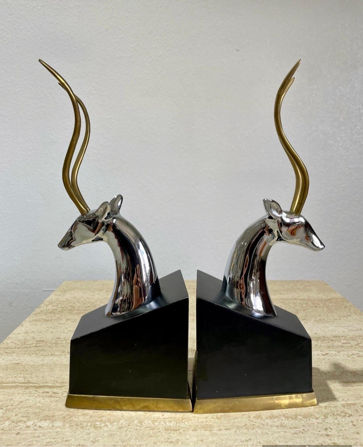 Pair of 1960’s Mid Century bookends. Chrome Gazelle heads with brass antlers on a black painted wood base with brass trim, and felted bottoms. Overall good vintage condition, some cosmetic wear typical with age and use. Some minor paint wear to