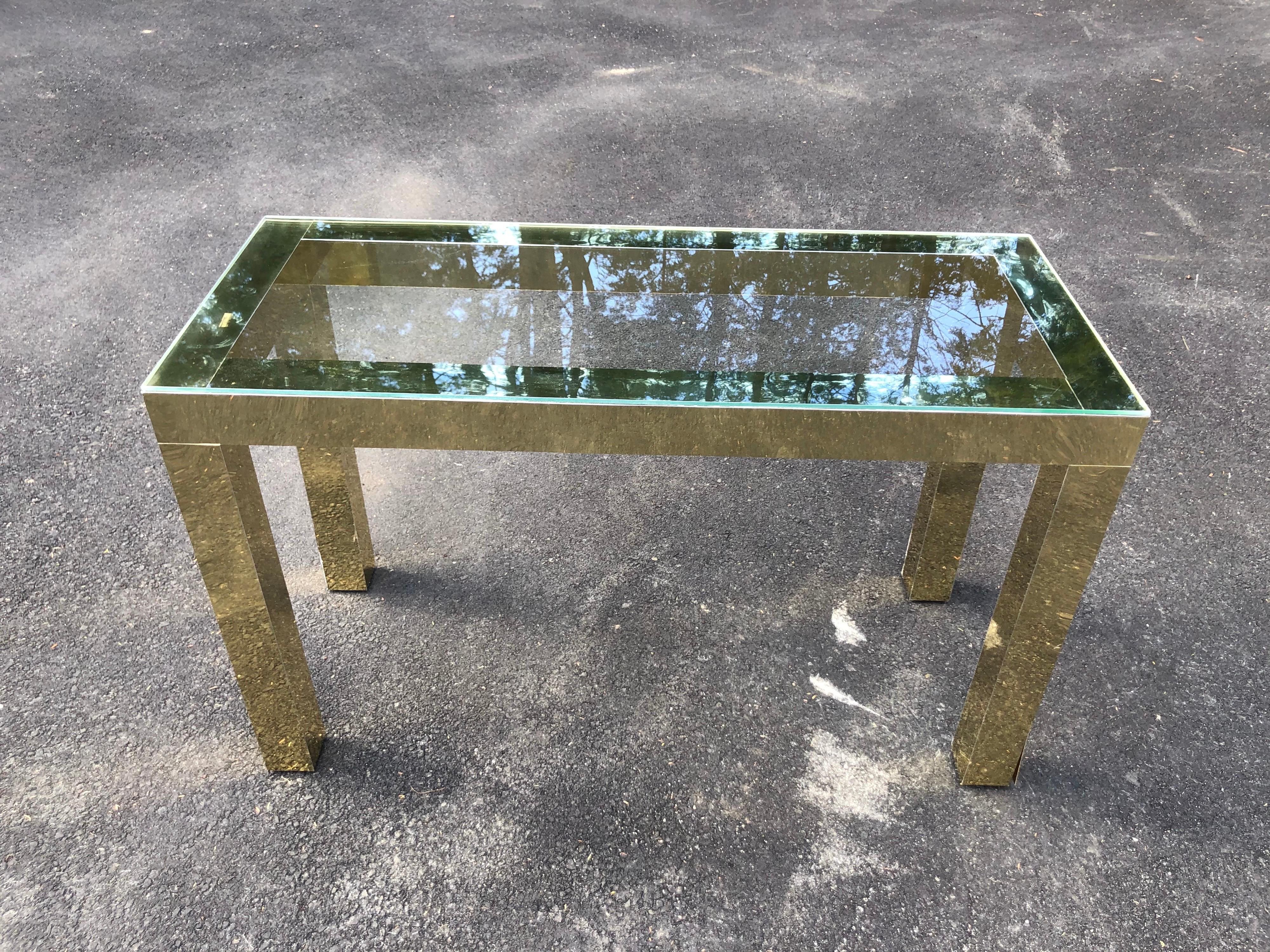 Mid-Century Modern brass and glass console. Laminated brass parsons design with clear glass top. Clean minimalist lines. Use as a console table, entry way or as a small vanity/desk.