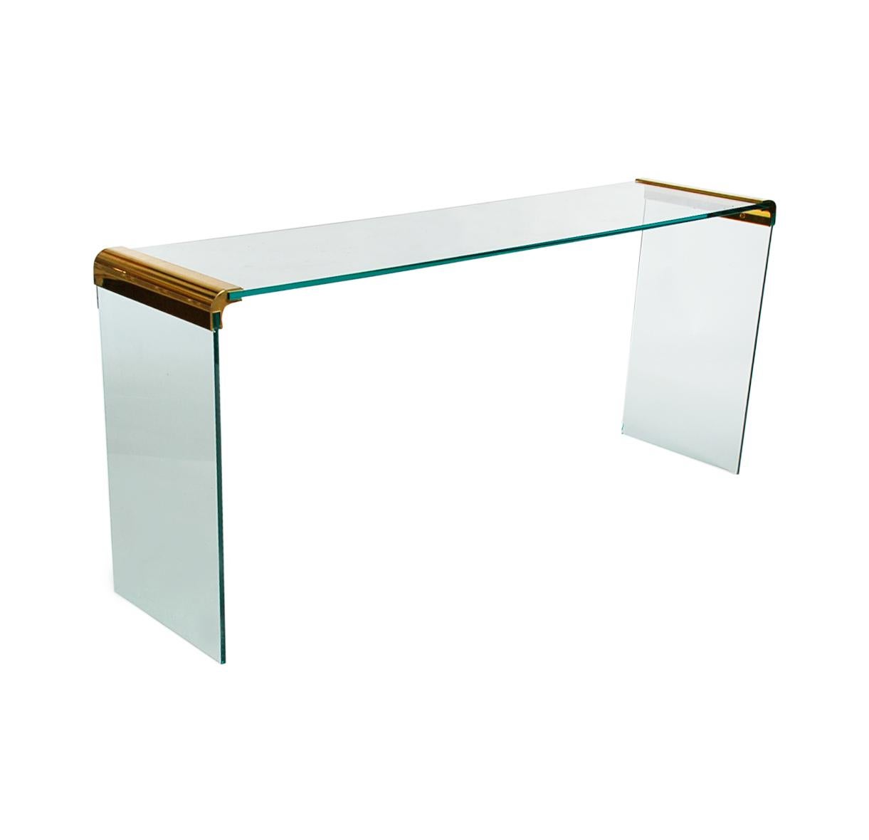 A simple and modern looking Classic designed by Leon Rosen and produced by Pace Furniture company in the 1960s. This console table features glass construction with brass bracket details.