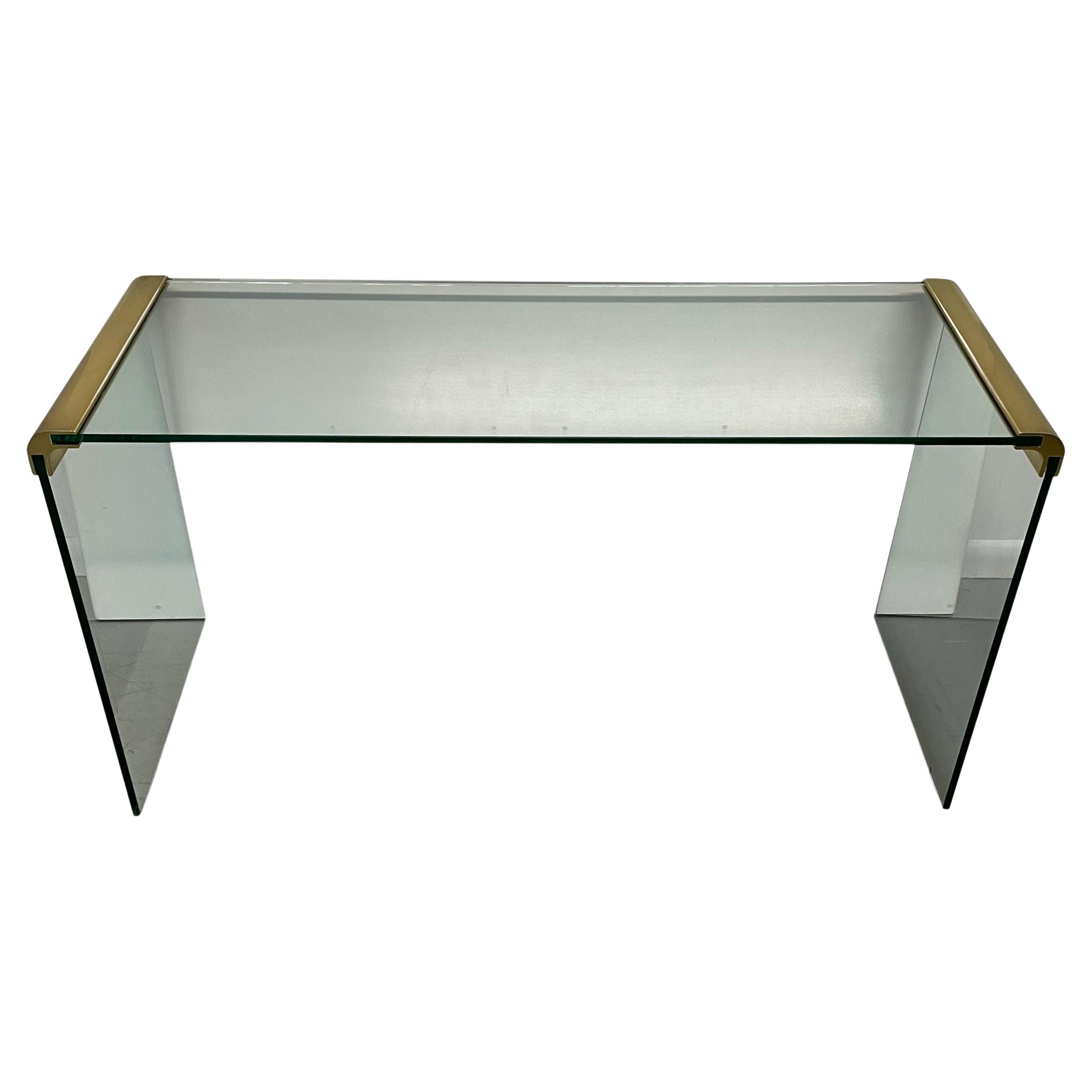 A simple and modern looking Classic designed by Leon Rosen and produced by Pace Furniture company in the 1960s. This console table features glass construction with brass bracket details. Excellent overall condition.