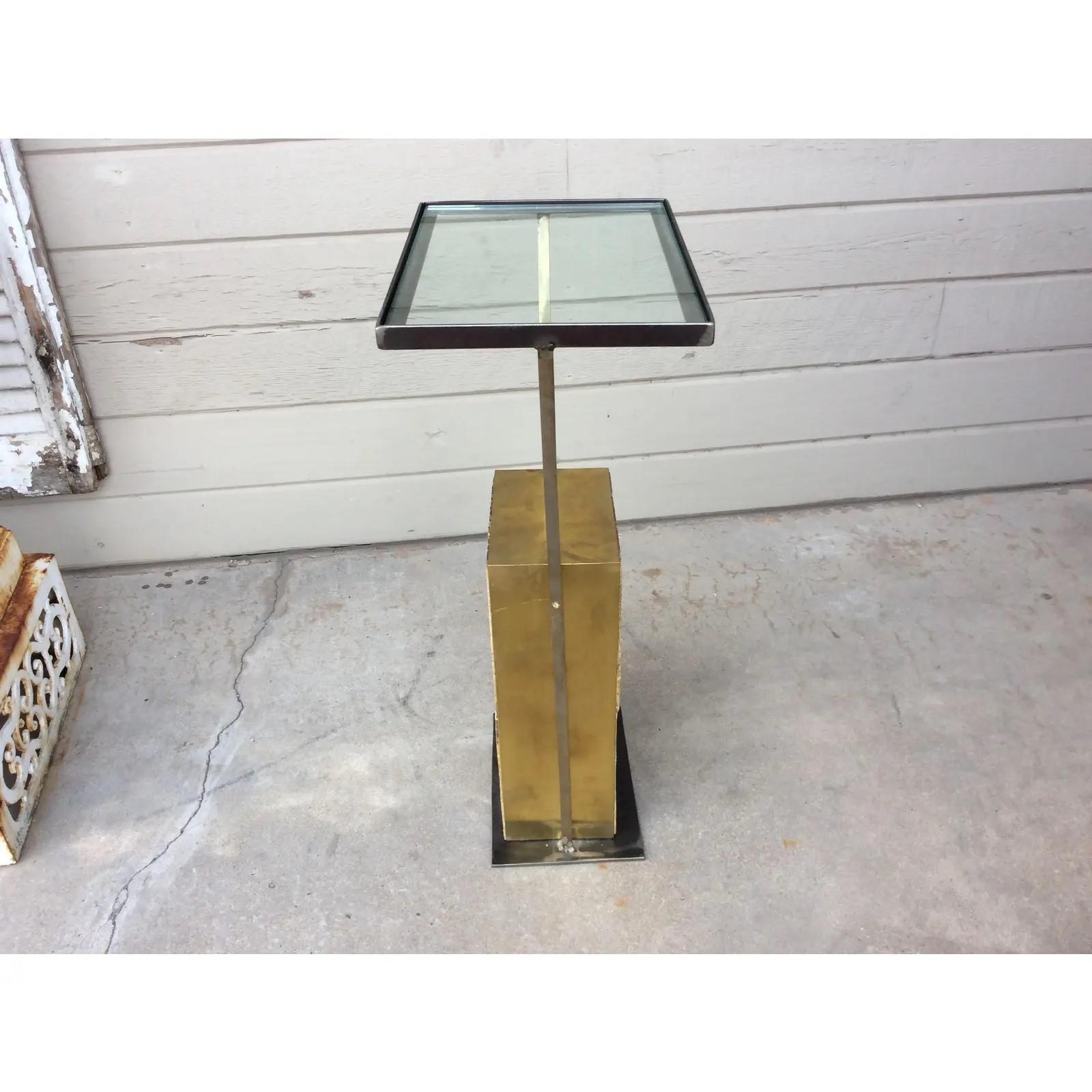 This Mid-Century Modern Brass and Glass Side Table is crafted from an original geometric style block obtained from a Mid-Century Modern building. The architectural block with its original patina, is lined on the outer edges with brass resting on an