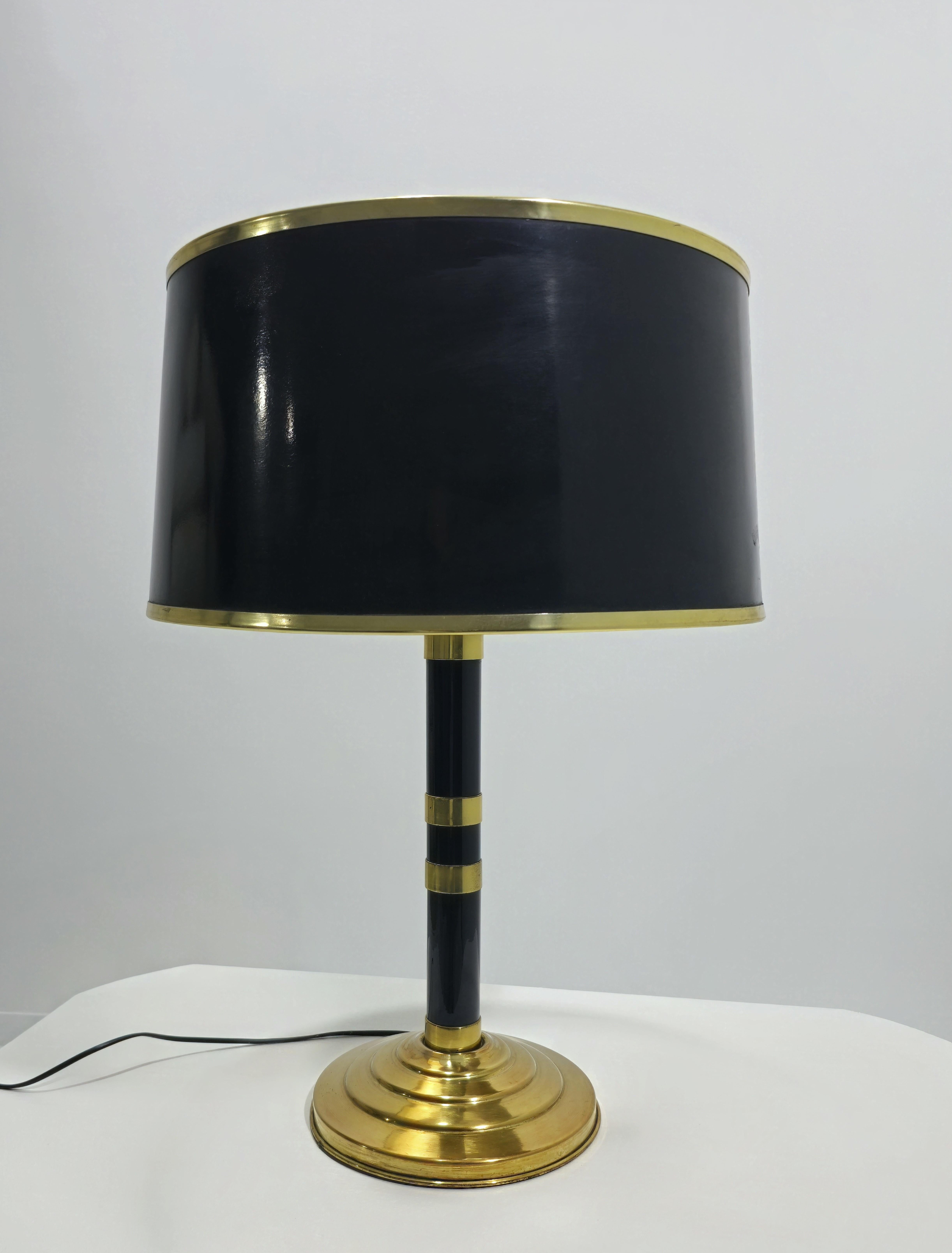 Elegante e rara lampada da tavolo in ottone e vetro smaltato nero. Base in ottone, collo in vetro smaltato nero. Abbellimenti in ottone. All'estremità, grazie a un anello, è possibile regolare l'altezza. Due luci E27. Paralume dorato all'interno e