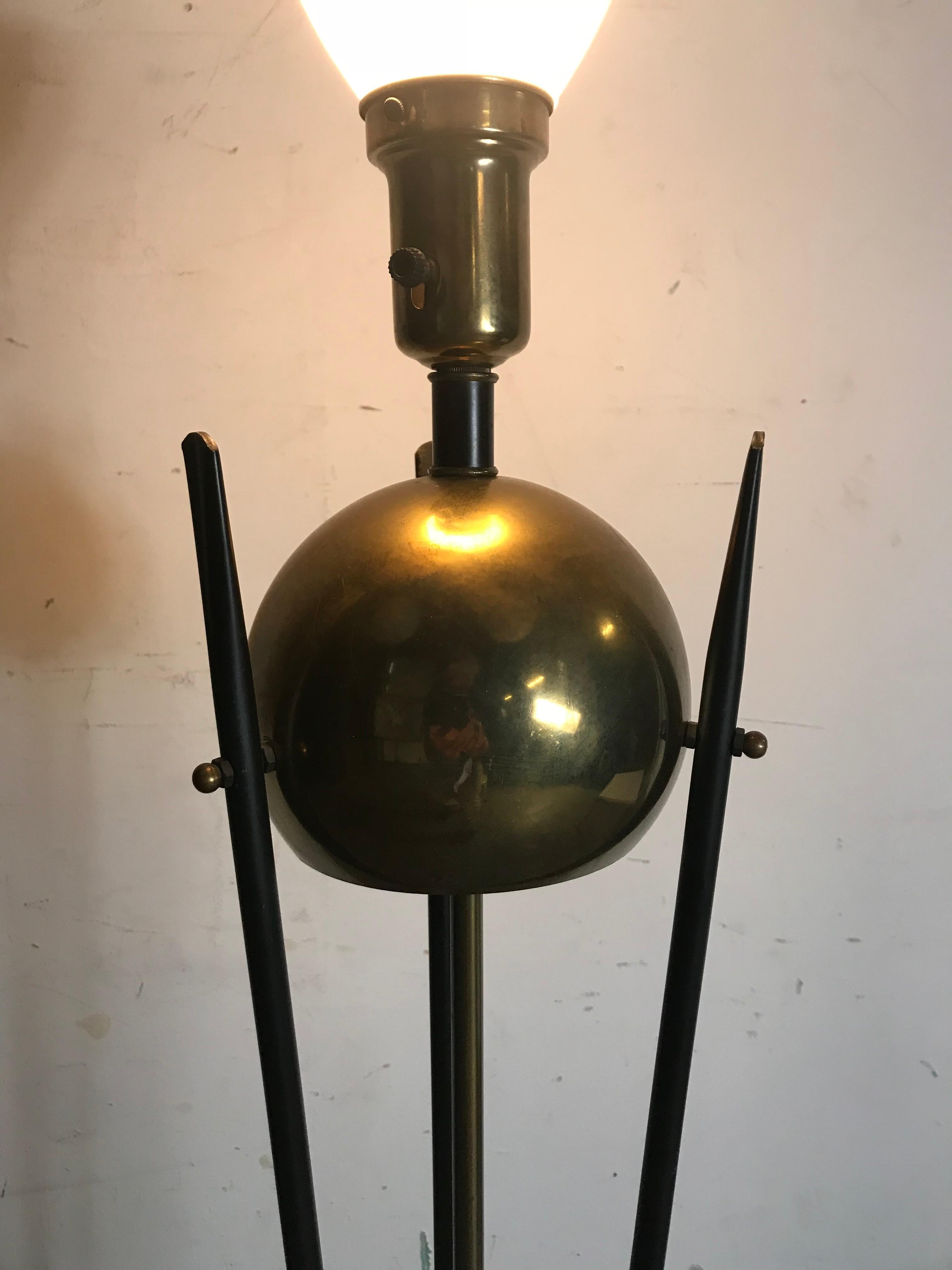 Mid-Century Modern brass and Iron floor lamp, attributed to Gerald Thurston for Lightolier, great design and quality featuring scrolled iron base with ball detail, large brass sphere, flattened hammed iron at top.3-way light switch.