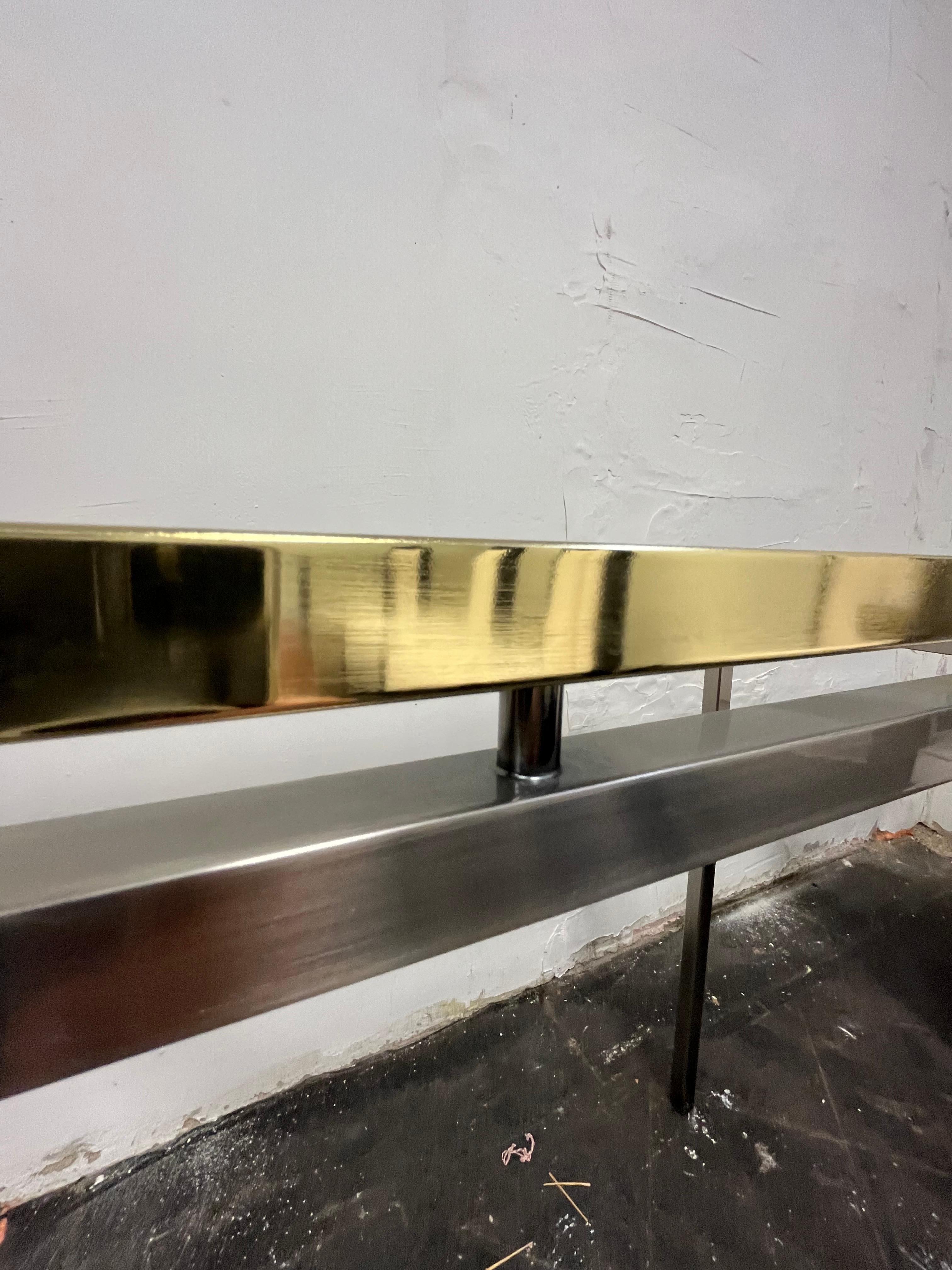 Classic mid century modern brass, steel and glass console table. Sleek sophisticated lines in a mid size. Polished brass upper frame with tightly set glass. Rod spacers to steel frame. 
Curbside to NYC/Philly $400