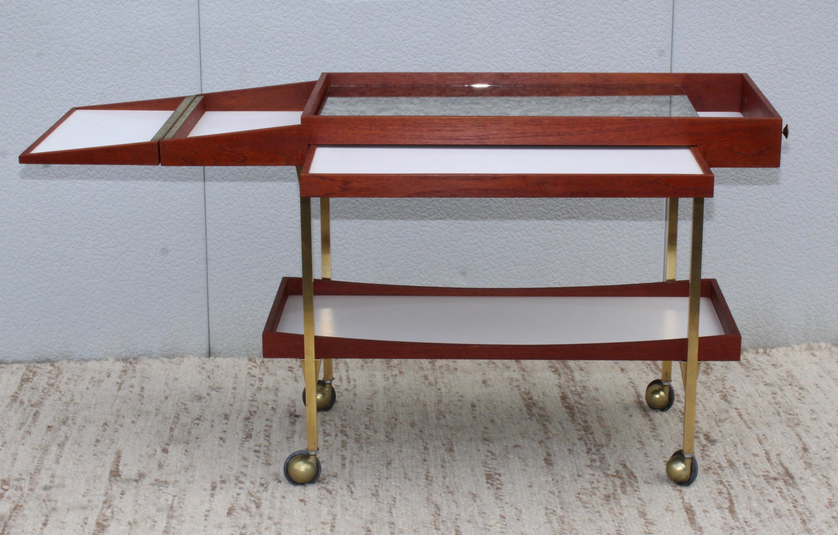 1960s Mid-Century Modern brass and walnut with antique mirror top bar cart in the style of Paul McCobb.

Length when fully open 55''.