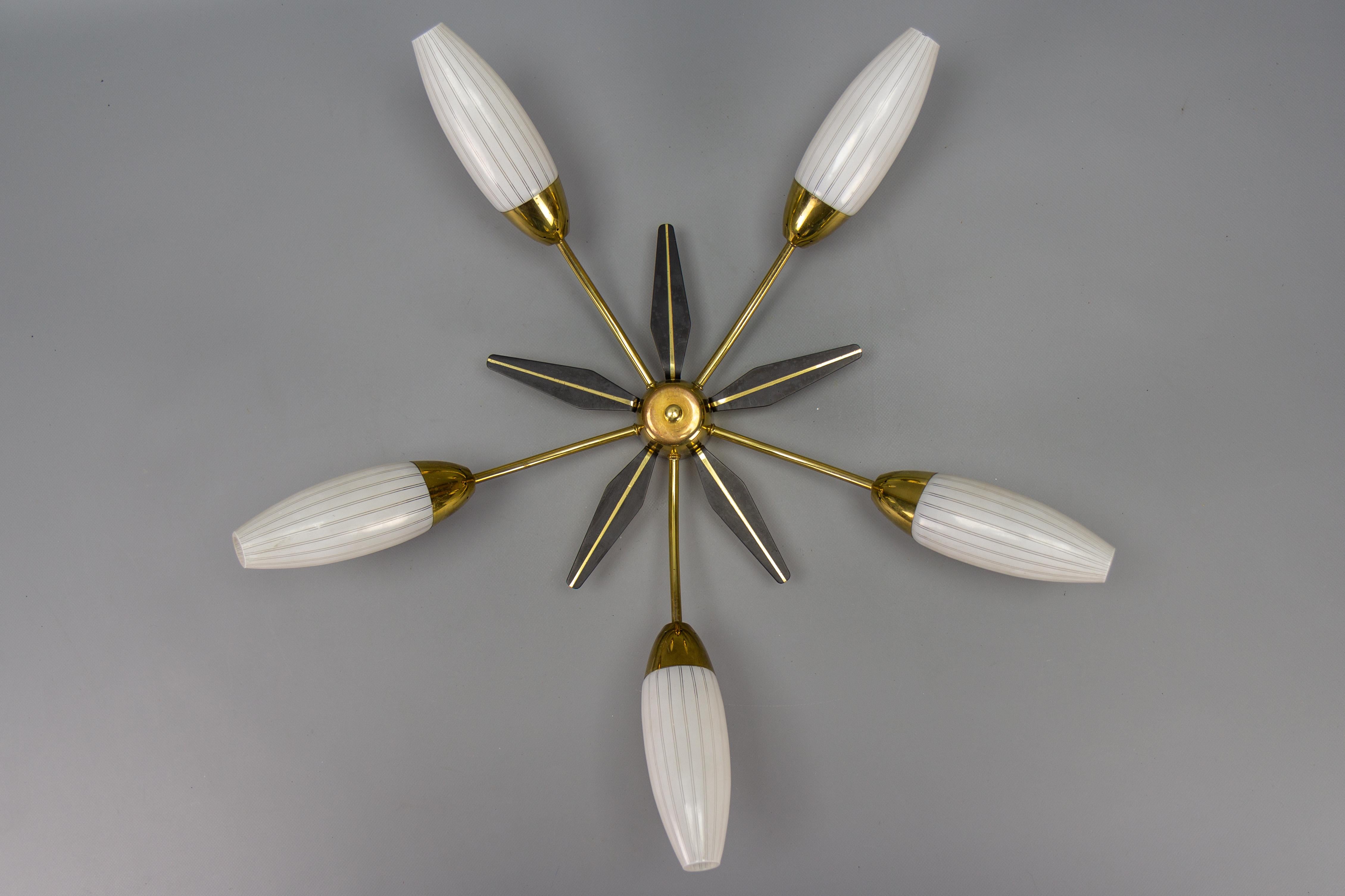 Mid-Century Modern brass and white glass five-light Sputnik flush mount, Italy, circa the 1950s.
This adorable vintage Sputnik-era flush mount features a brass frame with five arms, each with a white-colored glass lampshade, the center of the flush