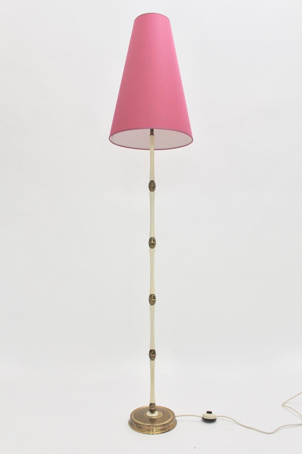 Mid Century Modern original amazing Italian brass and white vintage floor lamp from the 1940s consists of brass, metal and white lacquered beechwood.
Furthermore it presents a renewed lamp shade covered with strawberry pink textile fabric.
The shape