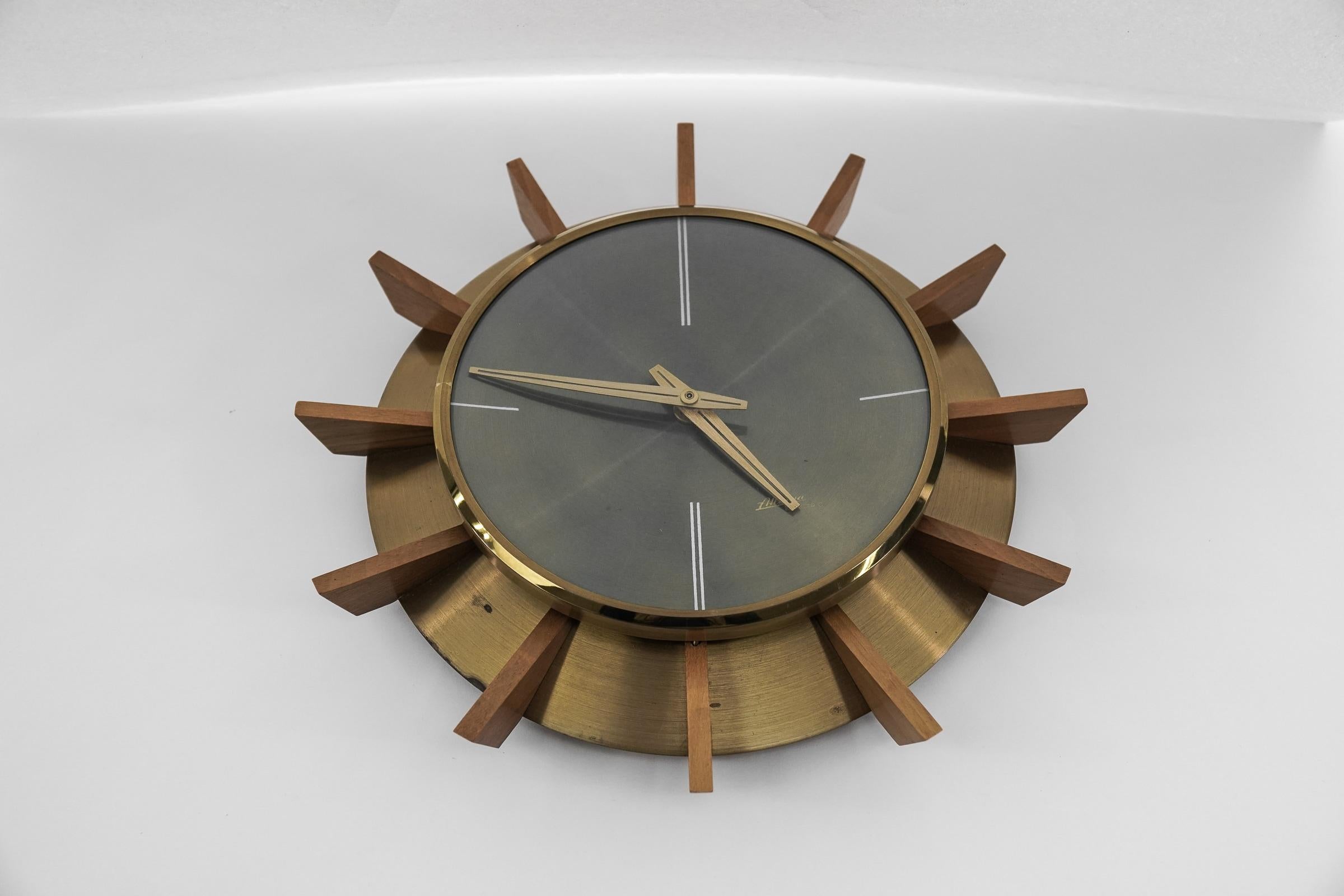 Stunning wall clock made of metal, brass, wood & glass. 

An eye catcher par excellence.

Made in Germany.

We have tested it and it works.

Electric, battery operated clock.