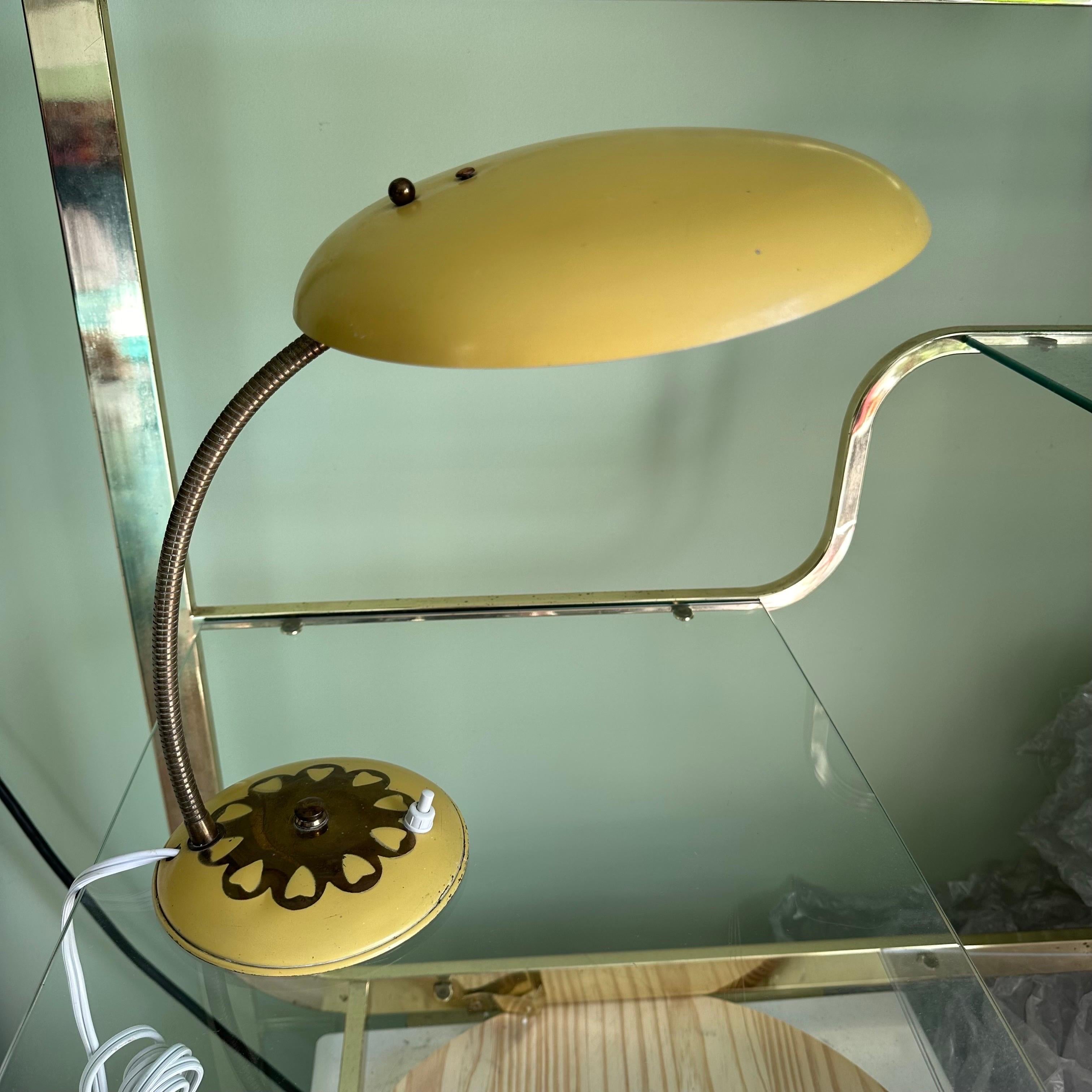 Charmante et unique lampe de table ou lampe de bureau vintage du milieu du siècle avec des détails en forme de cœur peints à la main. En métal patiné avec un abat-jour en forme de soucoupe ou de frisbee en jaune canari brillant et ensoleillé, avec