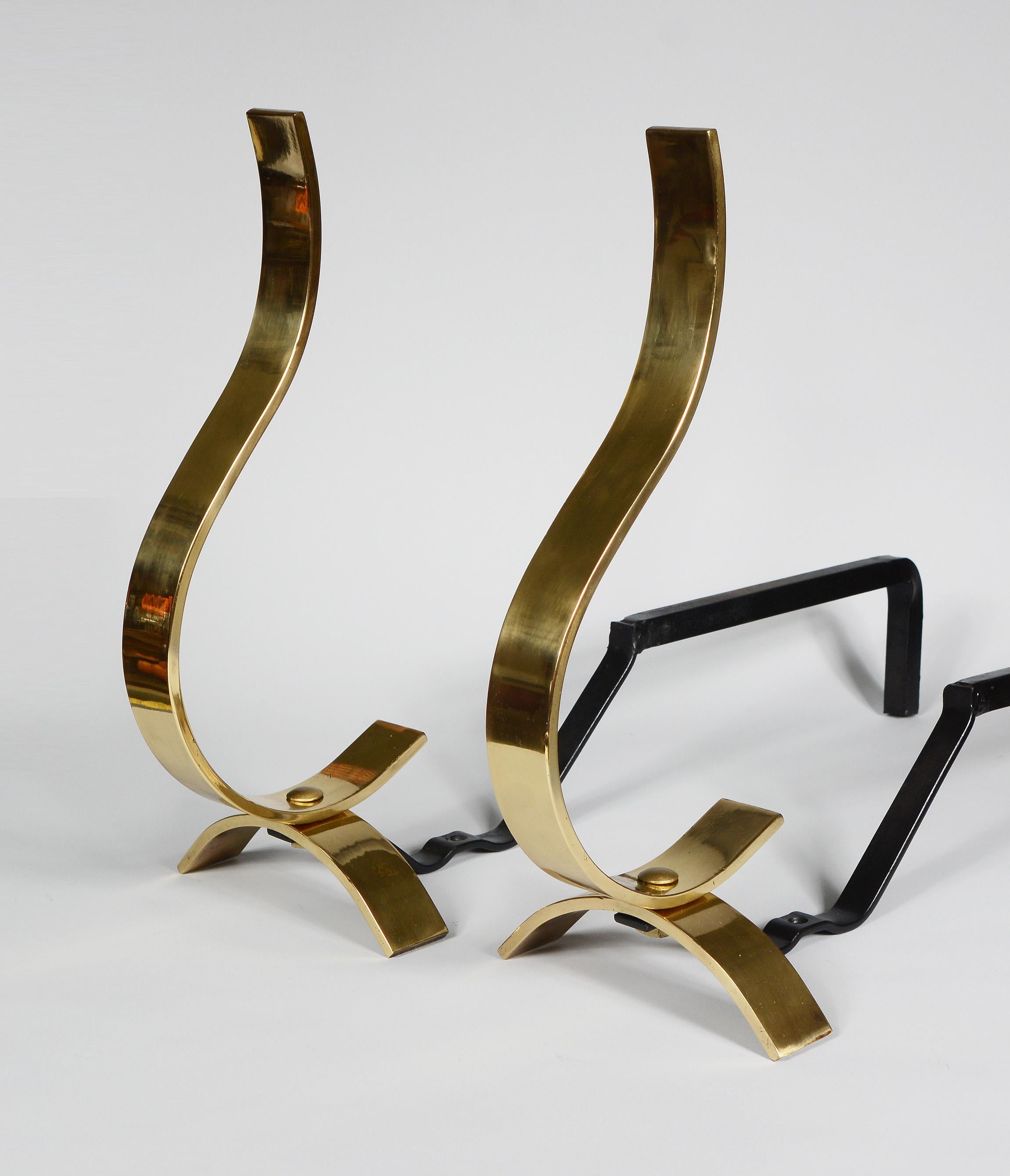 Modernist brass andirons. These have scroll shape on an arched shaped base. The top portion can also be turned sideways for a different look. There are some scratches and small dings. The brass portion is 6 inches deep.