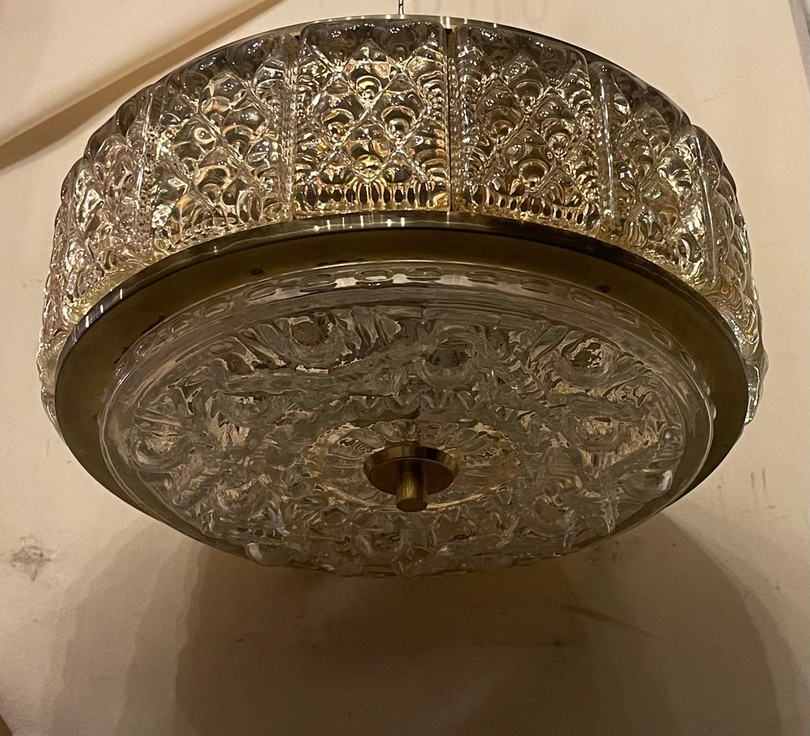 Merveilleux luminaire en laiton de style moderne du milieu du siècle avec panneaux de verre encastrés et bol central en verre à facettes avec colonnes en bois. Fabriqué par Carl Fagerlund et Orrefors, ce luminaire a été câblé avec 3 douilles