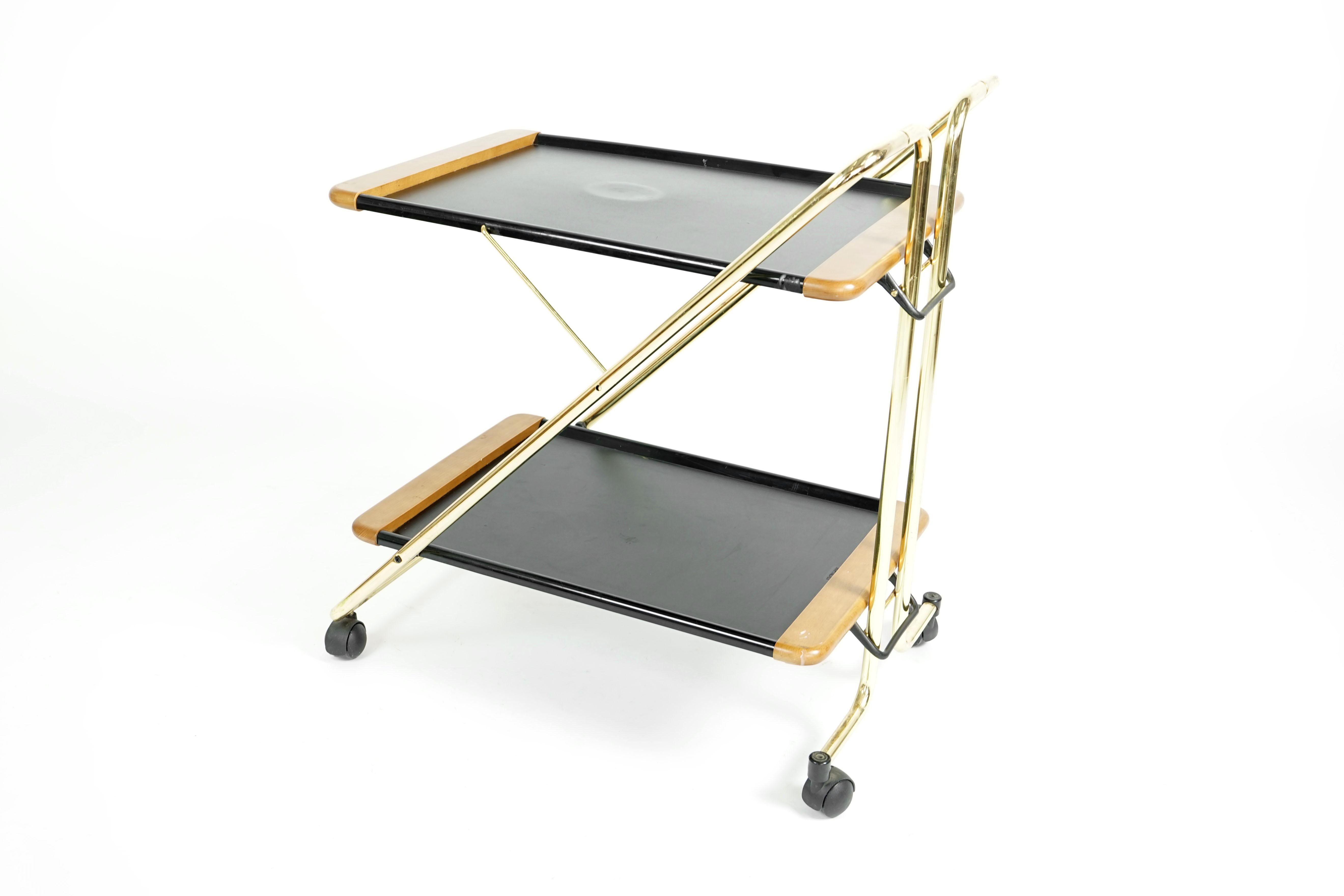 Wonderful Mid-Century Modern folding serving cart with a brass frame and black shelves. Original vintage conditions. Shows signs of use.
