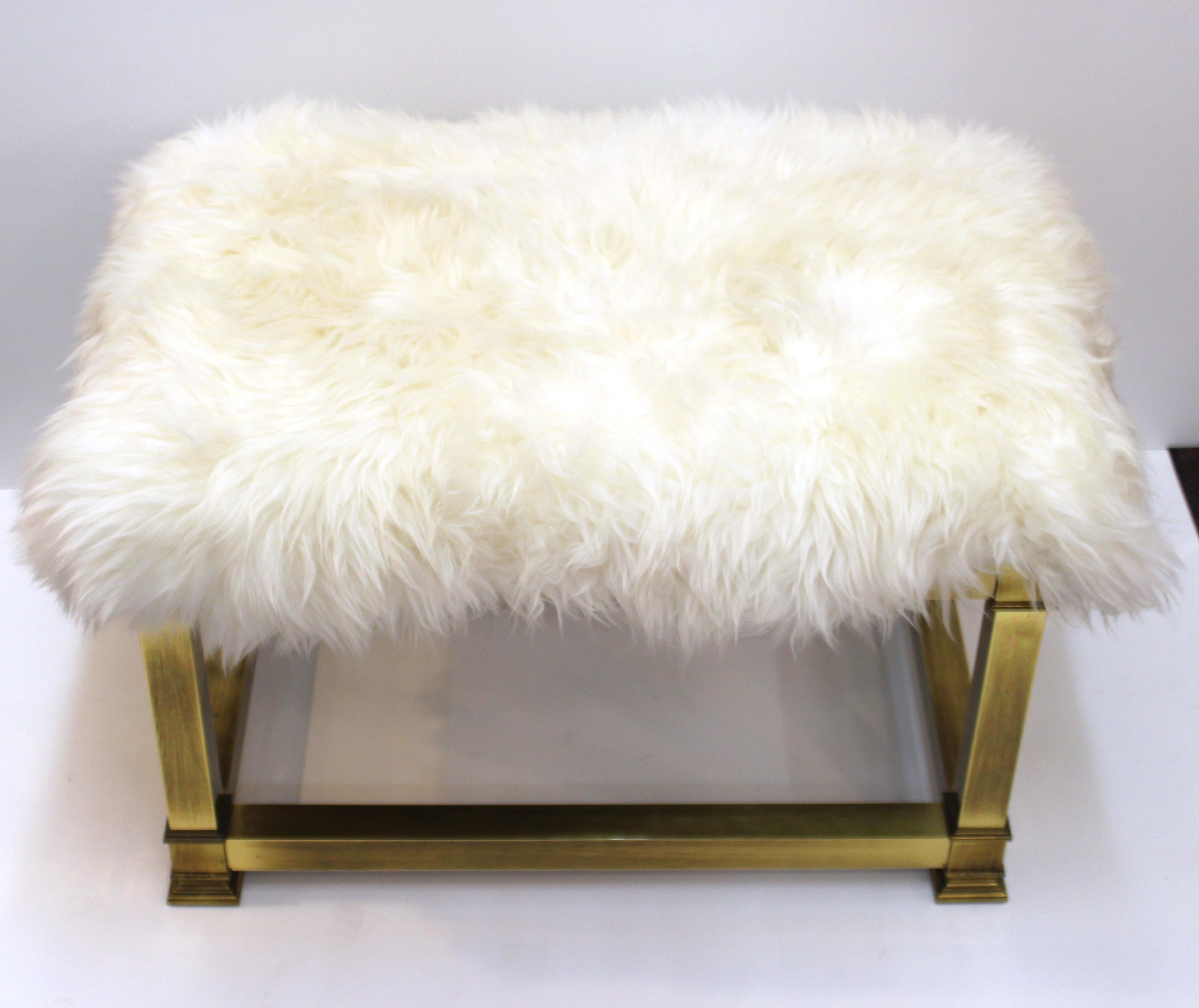 Mid-Century Modern brass bench, made in the United States during the 1970s, and newly reupholstered with real white sheepskin. The piece is in great vintage condition with some age-appropriate patina to the brass surfaces.