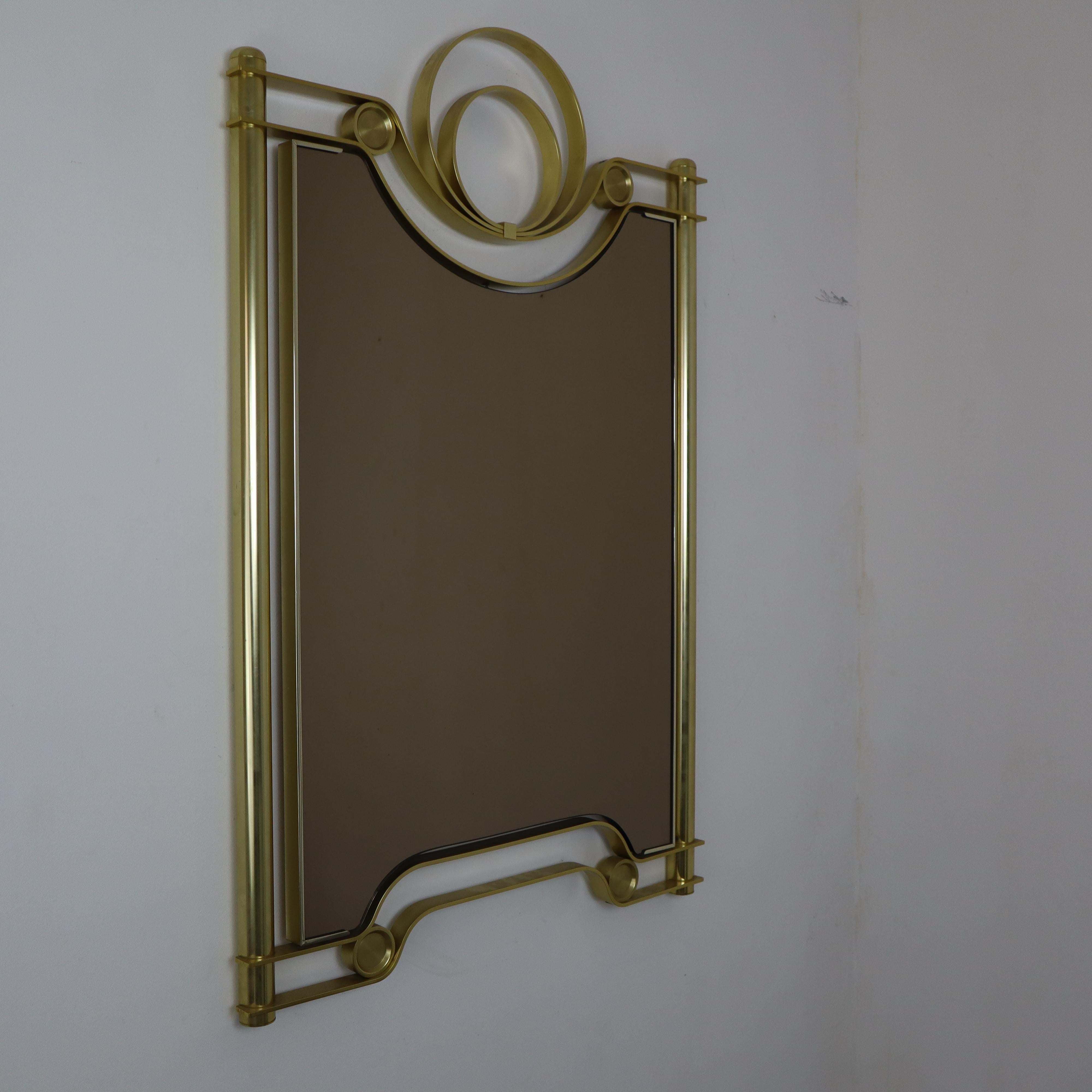 1970, Vintage Italian Modern Curved Satin Brass Wall Mirror Attributed Frigerio

This exquisite mid-century mirror, attributed to the renowned Italian designer Luciano Frigerio, features an incredibly decorative floating frame with curvilinear
