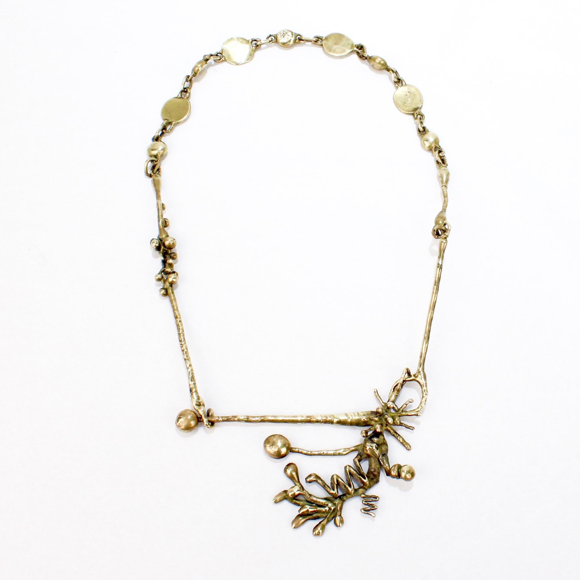 A mid-century modern brass Brutalist necklace.

In the style of Jack Boyd & Pal Kepenyes.

With an abstract organic Brutalist drop resembling a tree branch on a brass chain link necklace.

Simply a wonderful brass Brutalist
