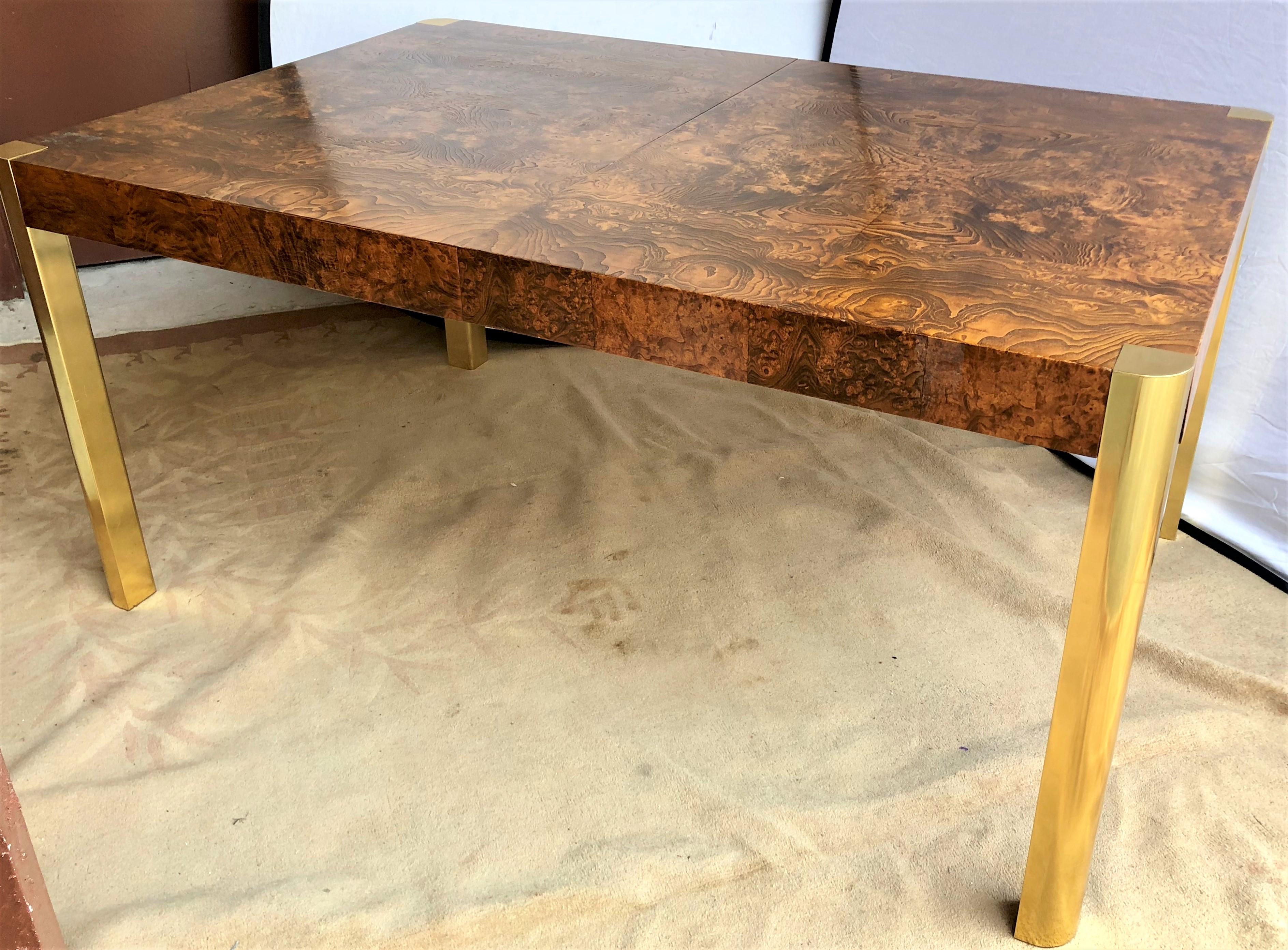Mid-Century Modern burled wood modernist brass column leg M ilo Baughman dining table with two leaves. Set on four demilune form brass toned column legs this sturdy and nicely designed dining table is certain to add luxury to any mid century modern