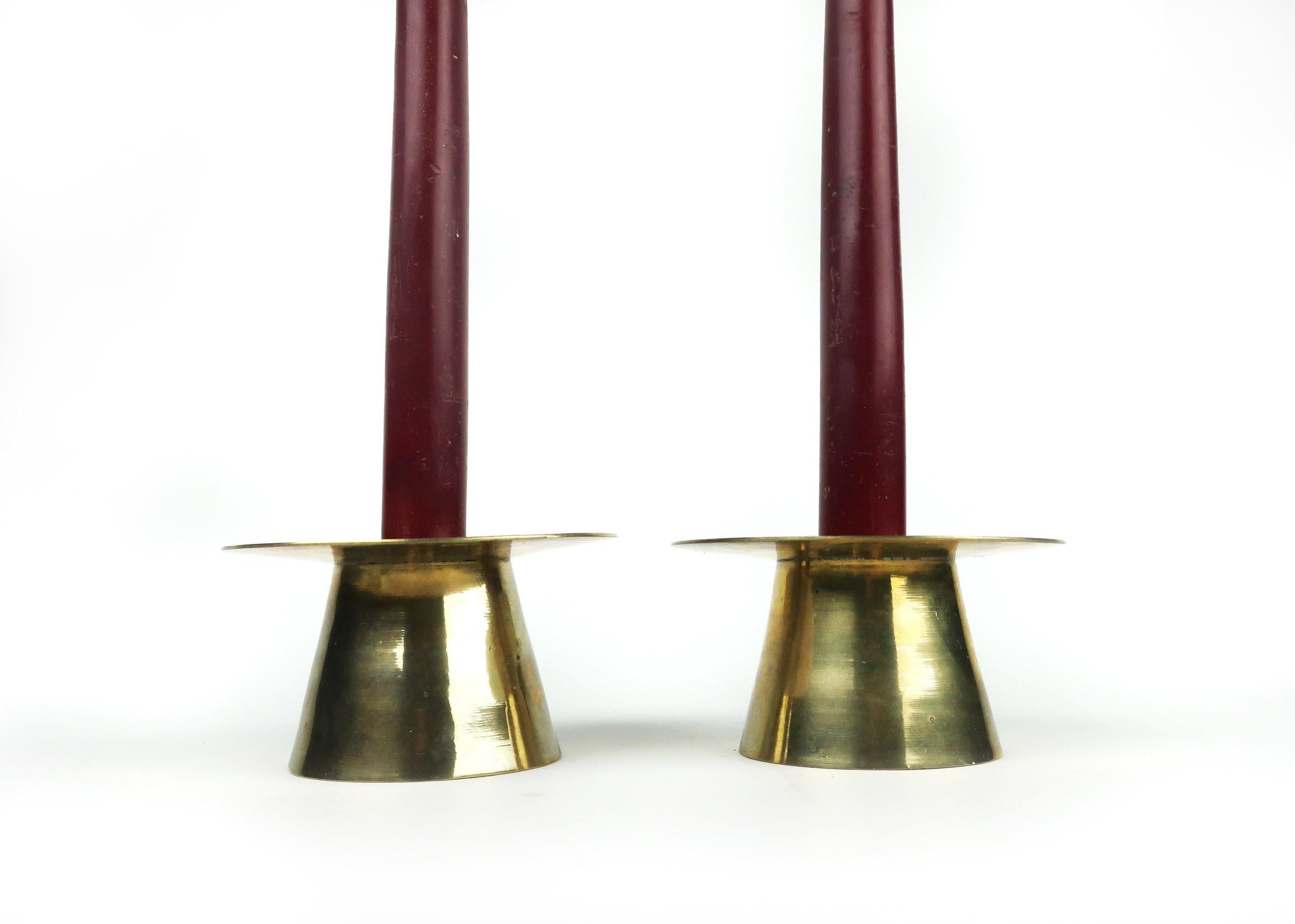 A pair of lovely midcentury or Danish modern brass candle holders with tapered cylindrical bases and wide plate top to catch dripping wax. Each has a removable insert for using with multiple sized candles.

In excellent condition. Designer and