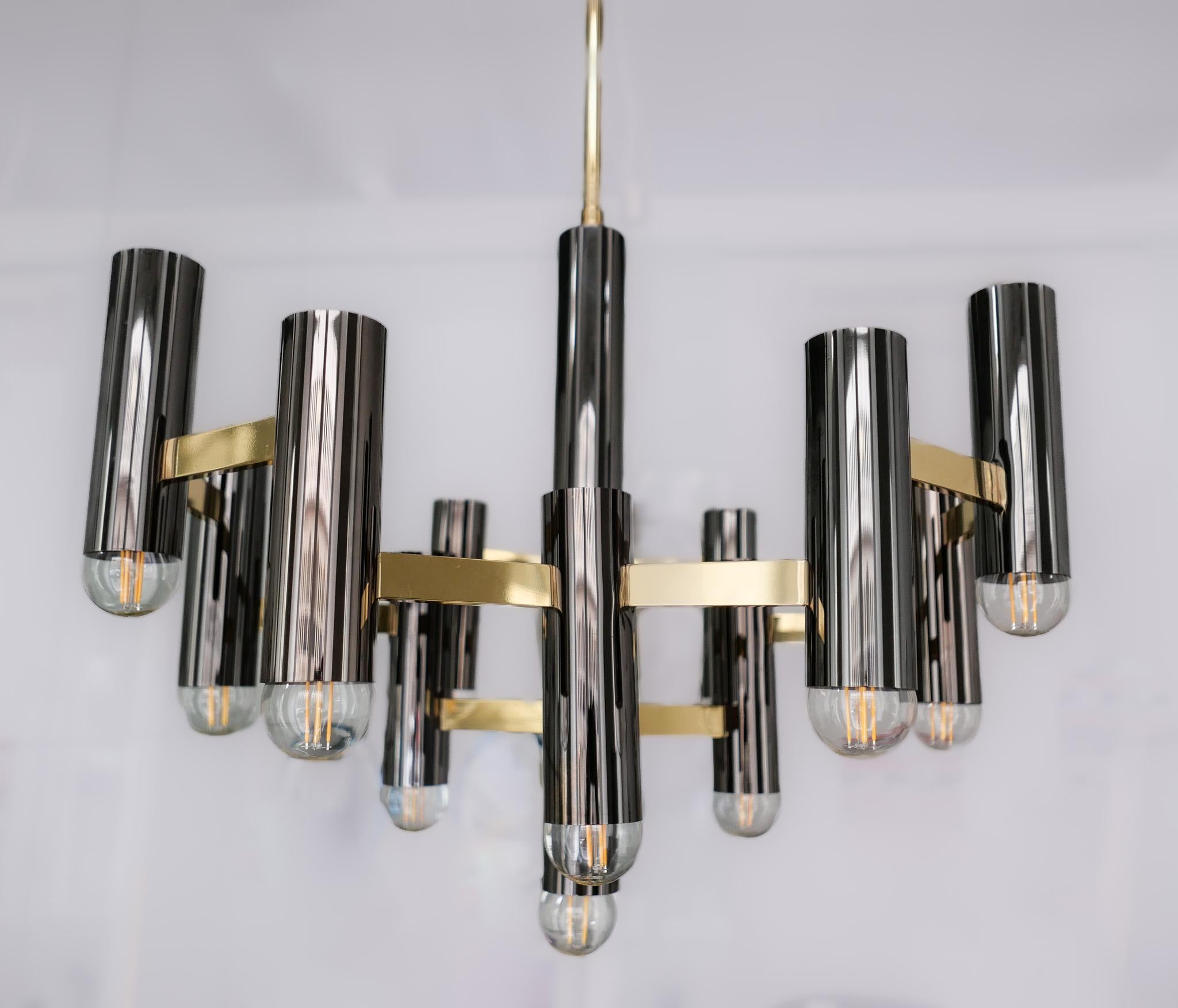 Mid-Century Modern brass chandelier by Gaetano Sciolari, Italy, 1970s.

This elegant chandelier was designed by the Gaetano Sciolari in the 1970s. The lamp consists of 13 tubular socket holders in shiny chromed metal. These 13 sockets are held by