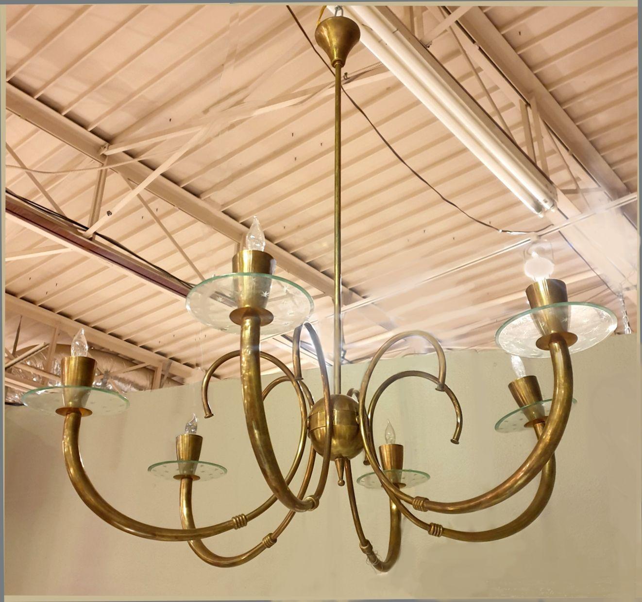 Mid century modern brass chandelier, Italy 1960s.
The large vintage chandelier is made of six arms/lights.
It's all brass, with clear etched glass bobeches. They have a carved little stars decor.
The chandelier has been rewired for the US, with