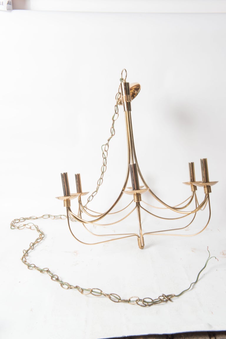 Mid-Century Modern streamlined six arm brass chandelier in the style of Tommi Parzinger. Includes canopy and chain.