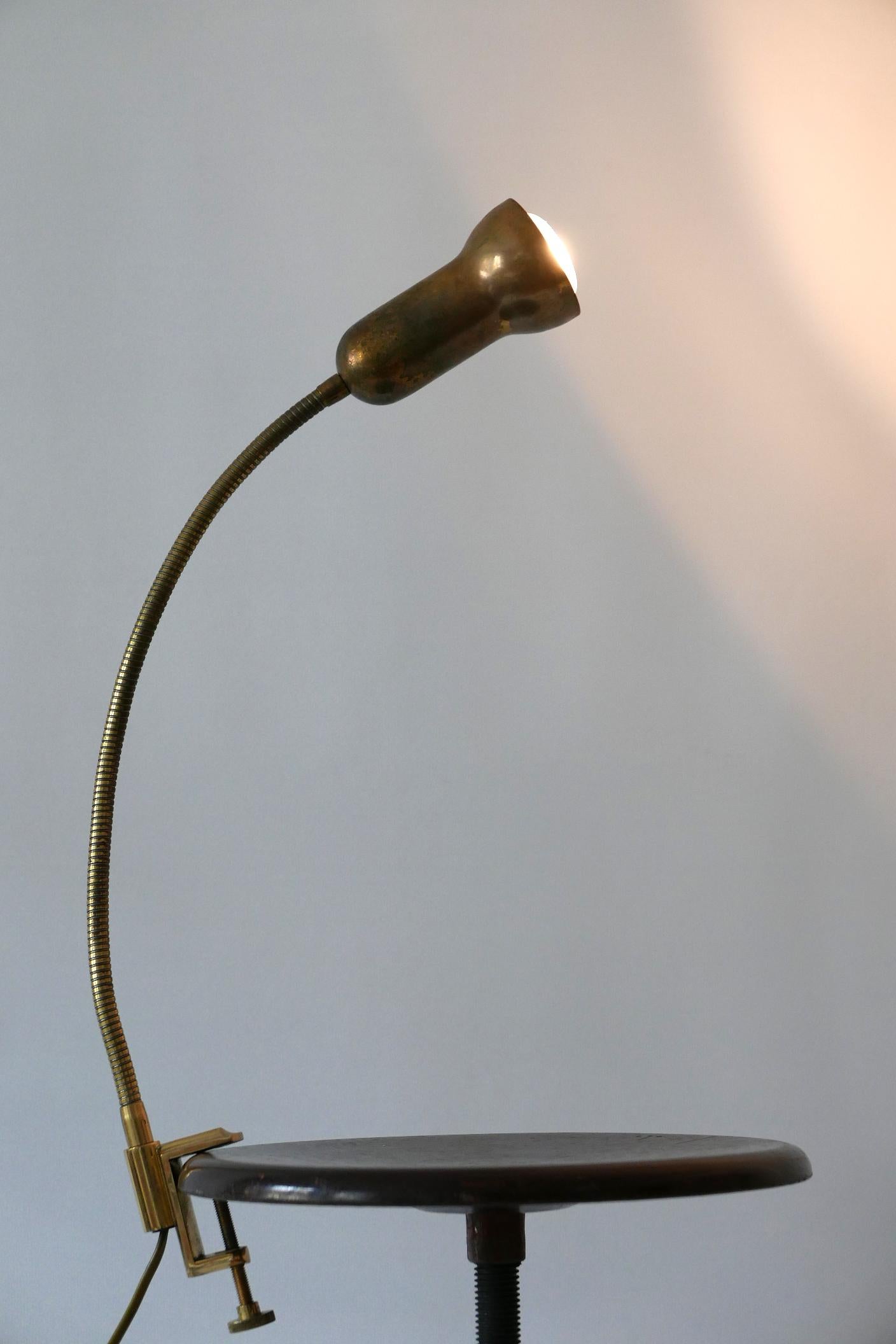 Lovely Mid-Century Modern brass clamp table lamp. Manufactured by Gebrüder Cosack, 1970s, Germany.

Due to the goose neck, the lamp is adjustable in various positions.

Executed in brass, the lamp needs 1 x E27 / E26 Edison screw fit bulb, is wired