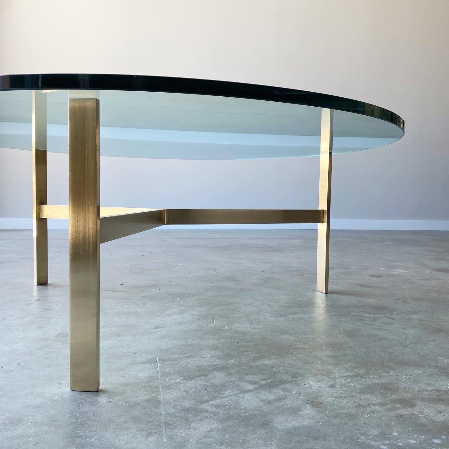 Minimal yet striking. A simple solid brass base, very well executed. Thick glass top, age appropriate wear throughout.

36” diameter, 16 1/2” high