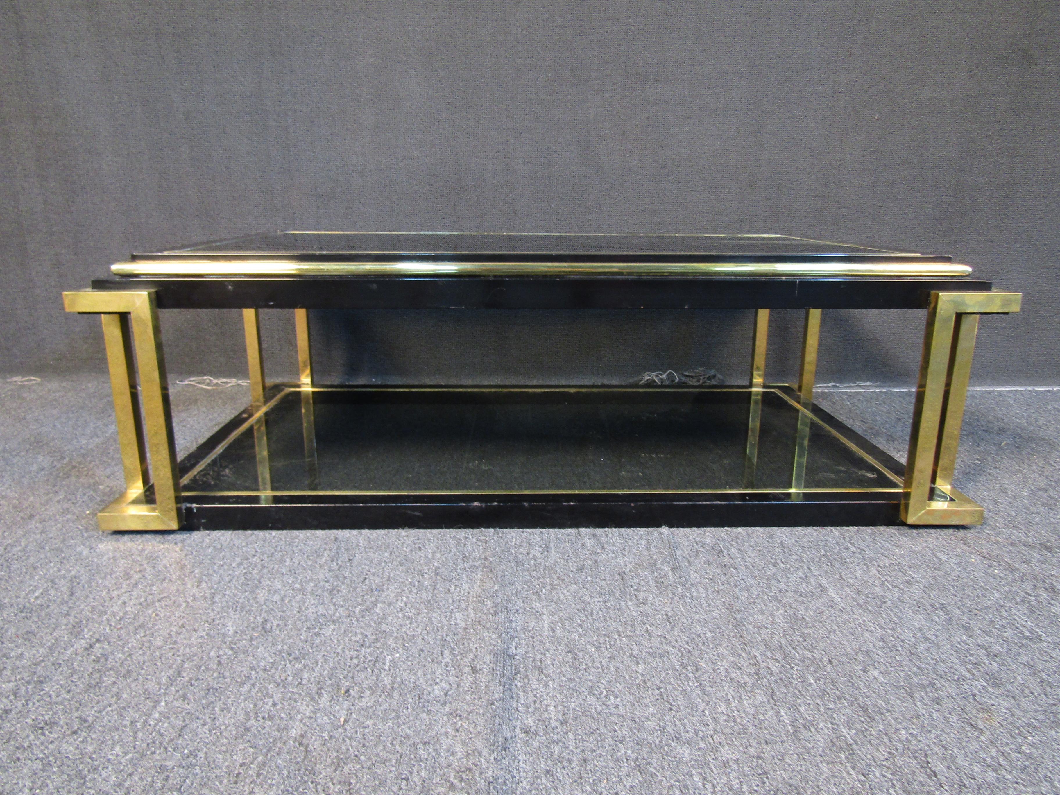 This ornate vintage coffee table features panels of dark glass combined with a frame of brass and ebonized components. Please confirm item location with seller (NY/NJ).